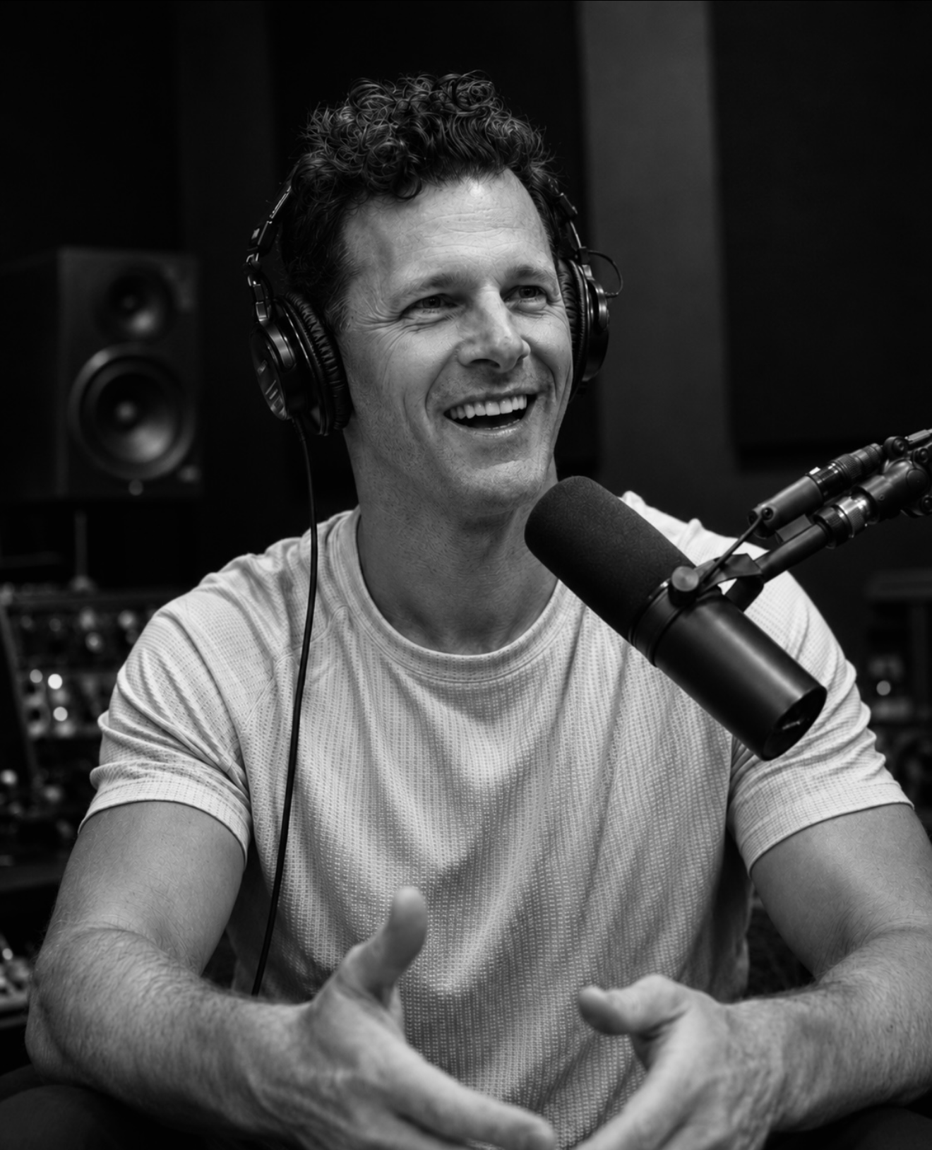 Michael Ockrim recording a podcast interview, wearing headphones at a studio microphone