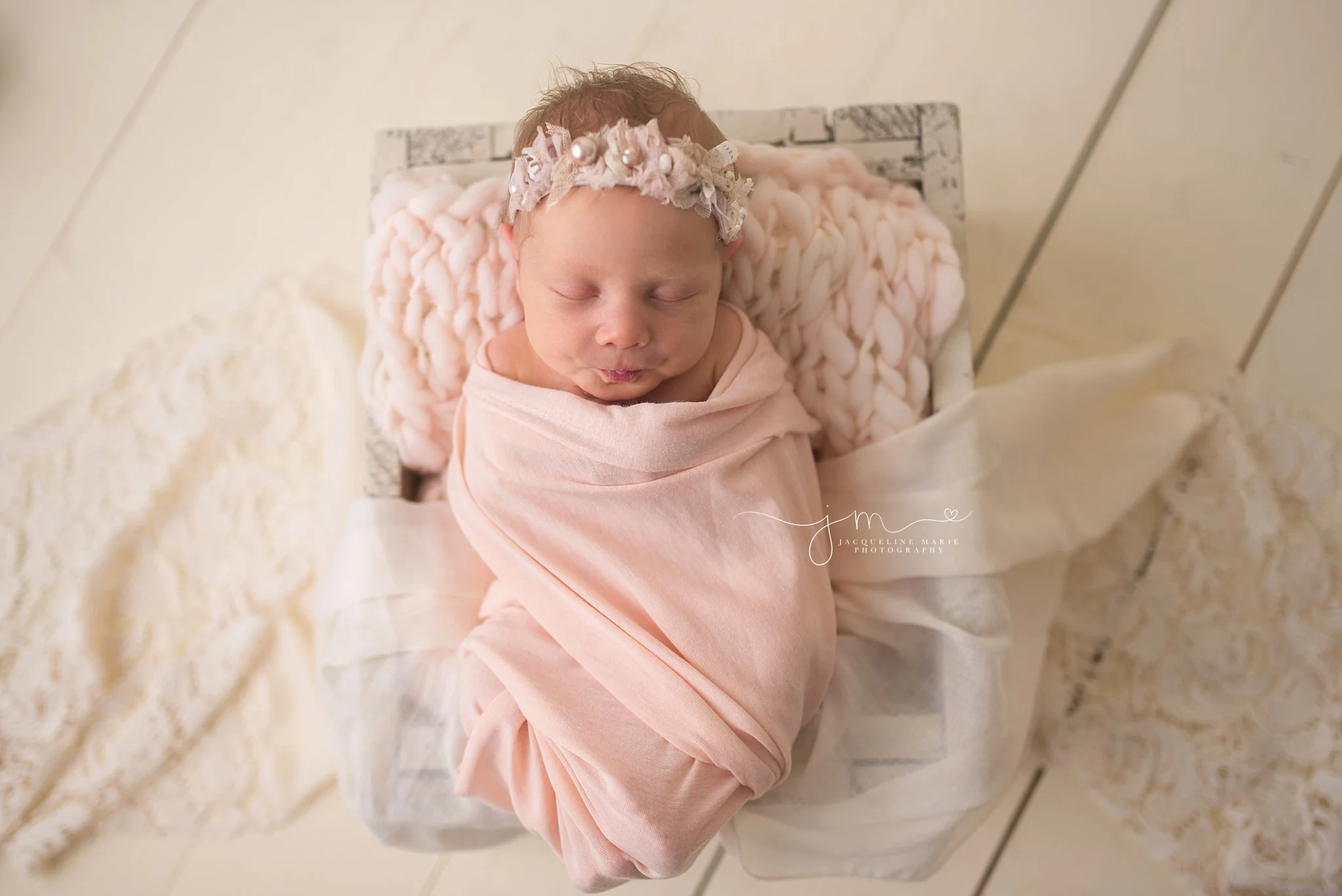 Newborn baby portrait features baby swaddled in pink wrap while sleeping in Columbus Ohio at Jacqueline Marie Photography
