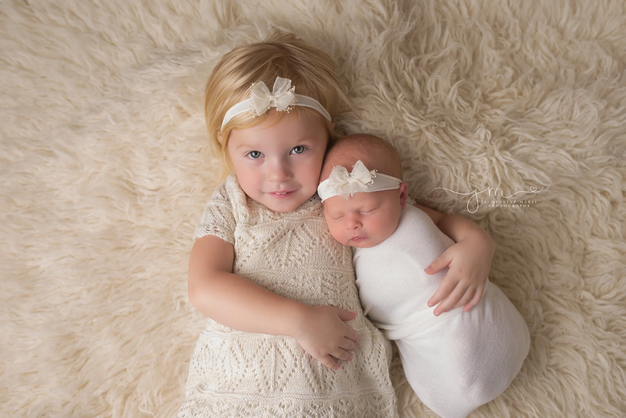 Columbus Ohio newborn portrait features big sister hodling newborn baby at Jacqueline Marie Photography studio