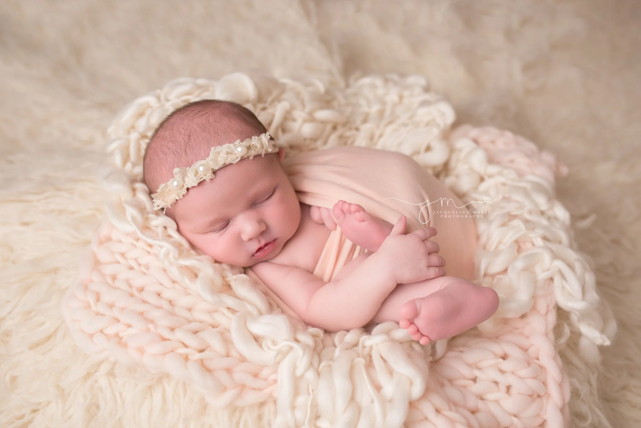 Columbus Ohio newborn baby featured in pink wrap and pearl headband at Jacqueline Marie Photography studio
