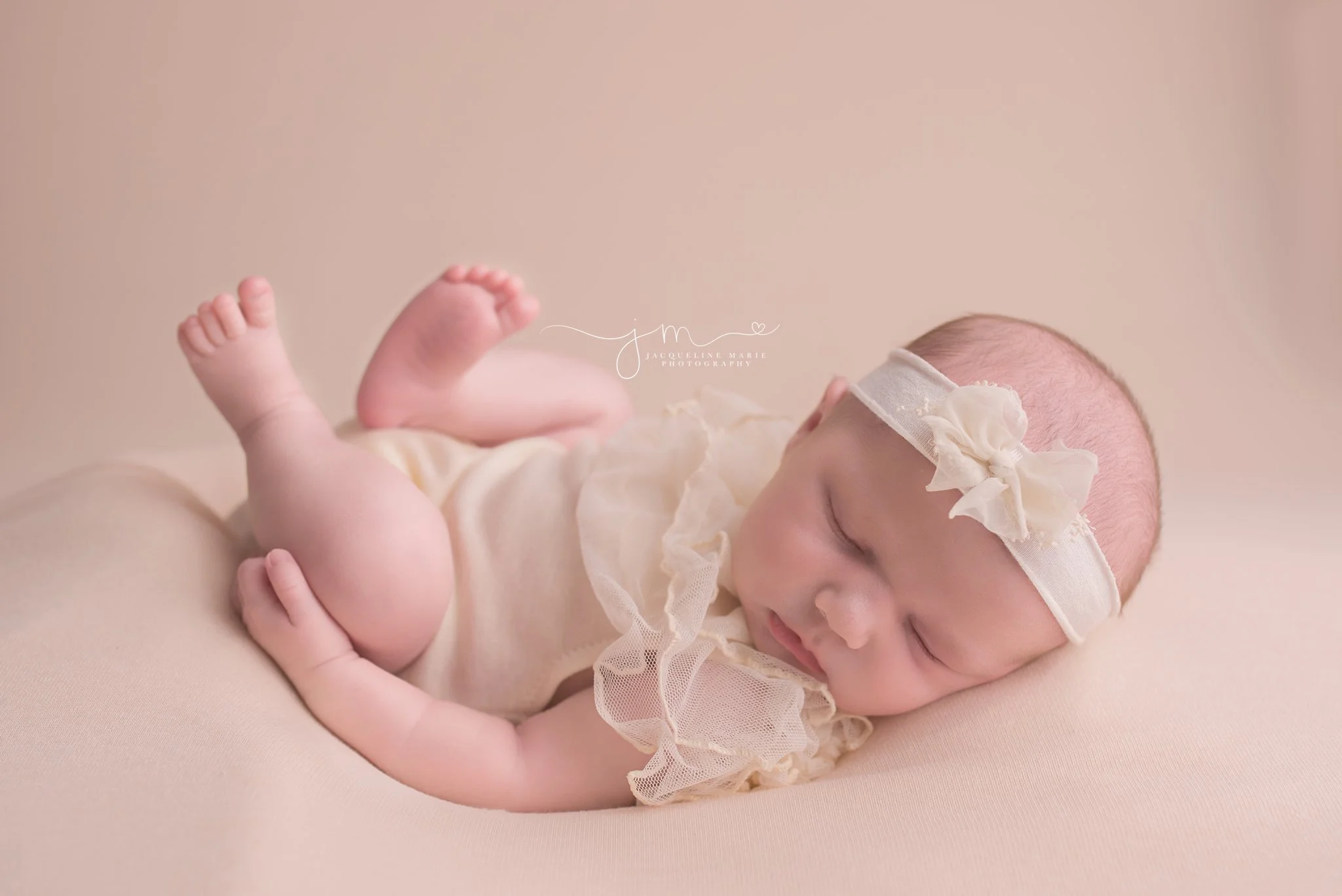 17 day old newborn wears cream lace romper and matching headband for portrait at Jacqueline Marie Photography in Columbus Ohio