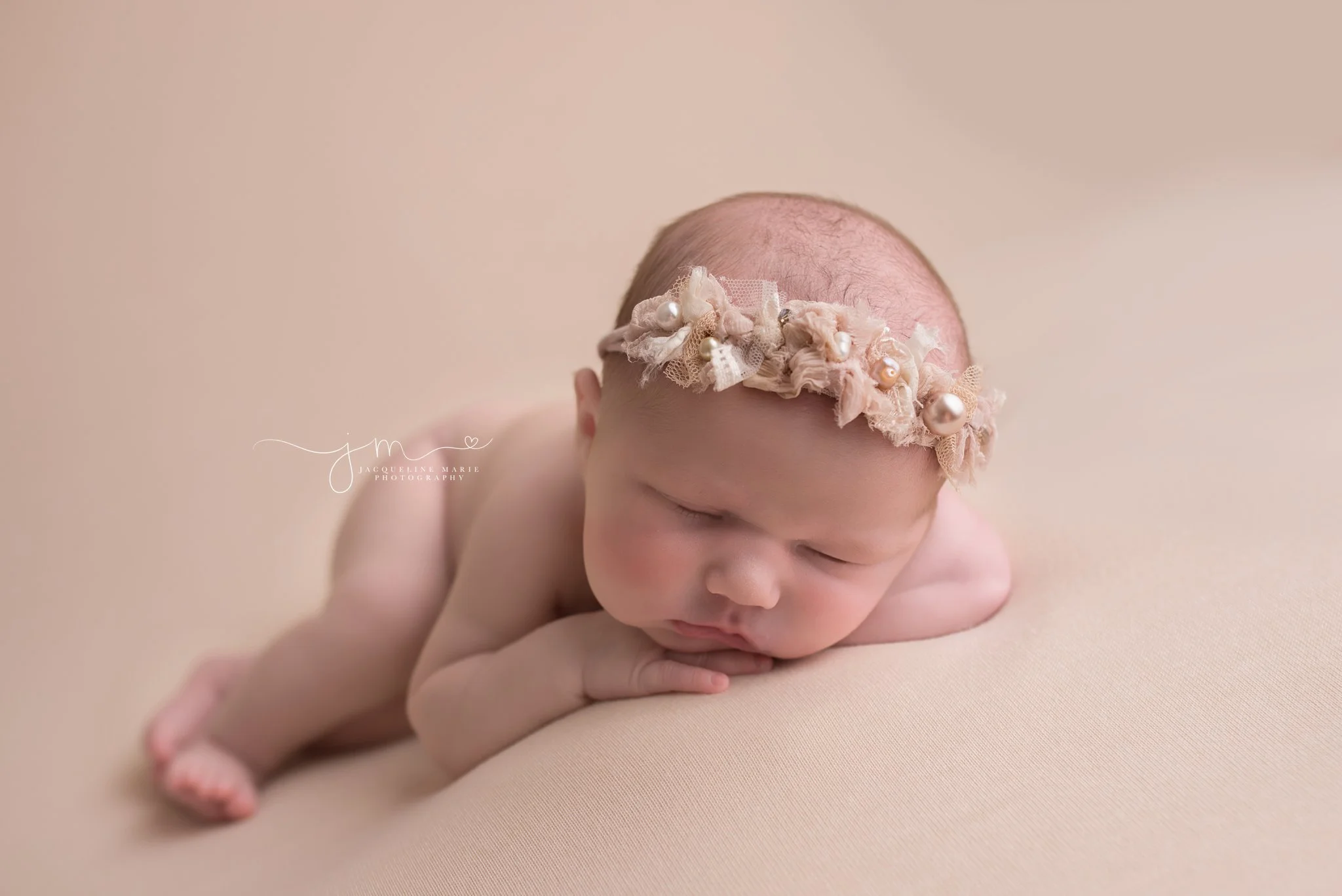Columbus Ohio newborn wears pearl headband for portrait on blush pink blanket at Jacqueline Marie Photography
