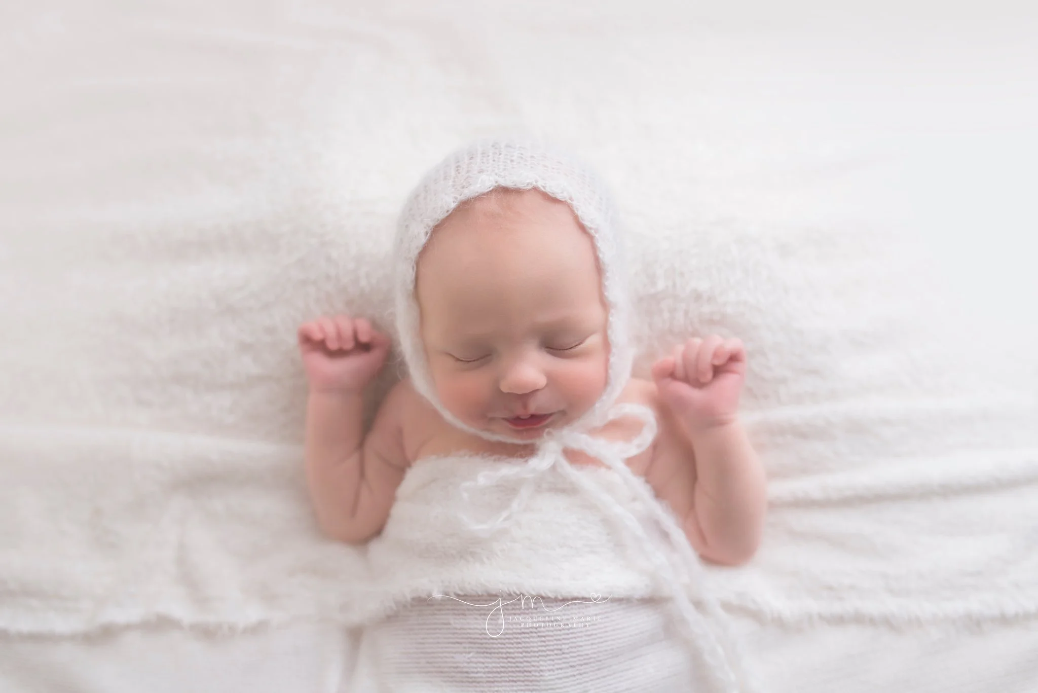 Jacqueline Marie Photography features newborn photography portrait of newborn baby girl wearing a white bonnet in Columbus Ohio