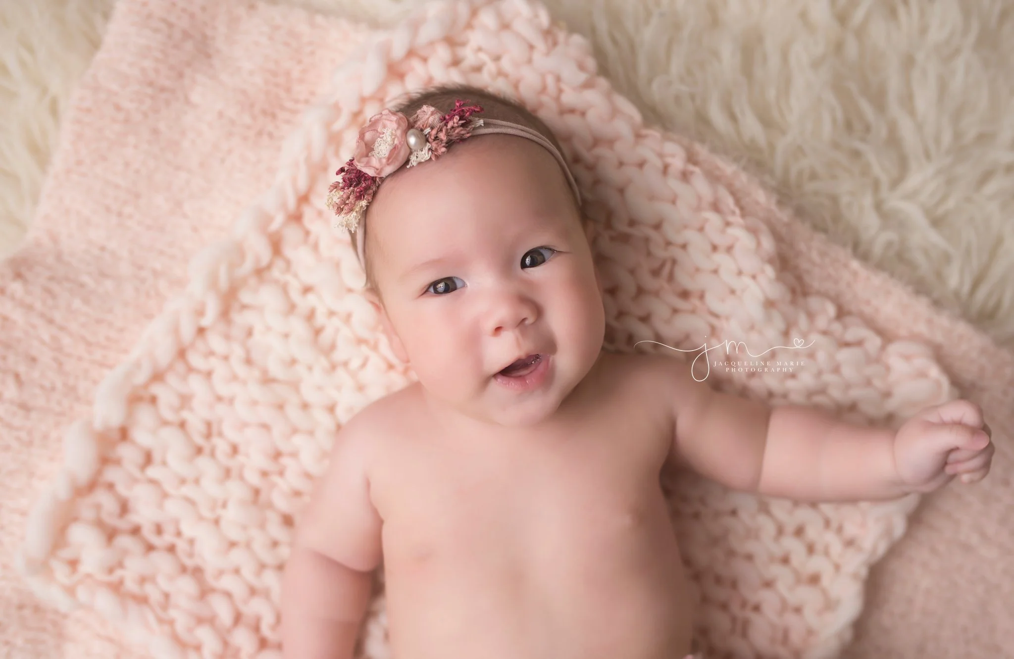 Columbus Ohio 3 month old baby girl smiles while wearing pink headband for milestone portrait session at Jacqueline Marie Photography studio