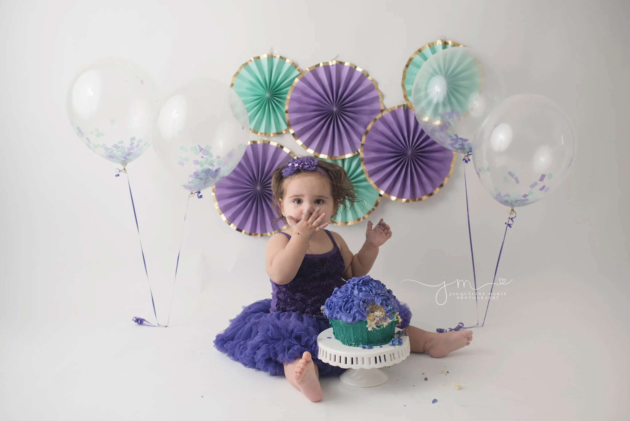 one year emma eats cake during her cake smash pictures to celebrate her first birthday in columbus ohio