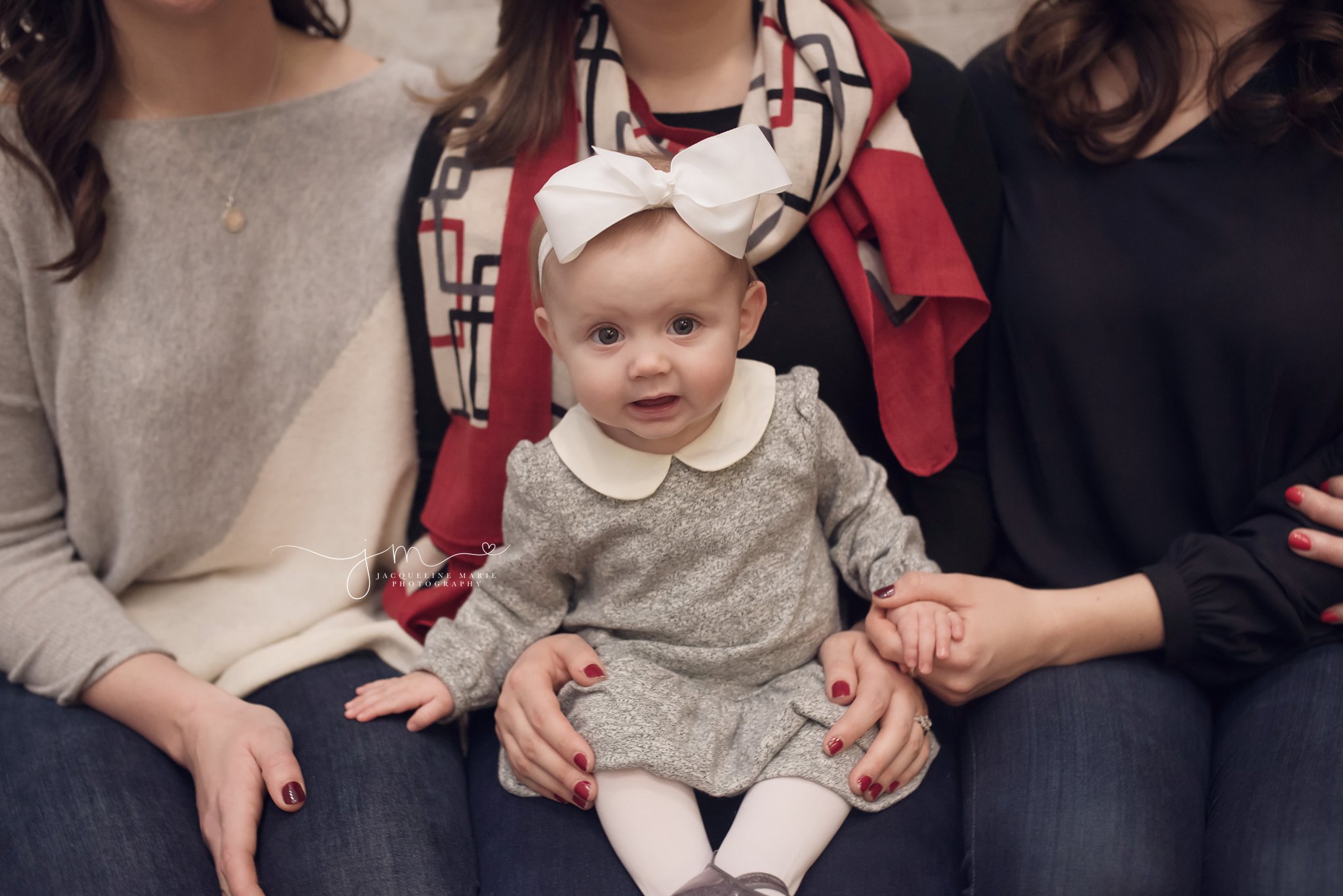 6 month old baby girl wears gray dress and white bow for family pictures at the Hilton Hotel in Columbus Ohio 