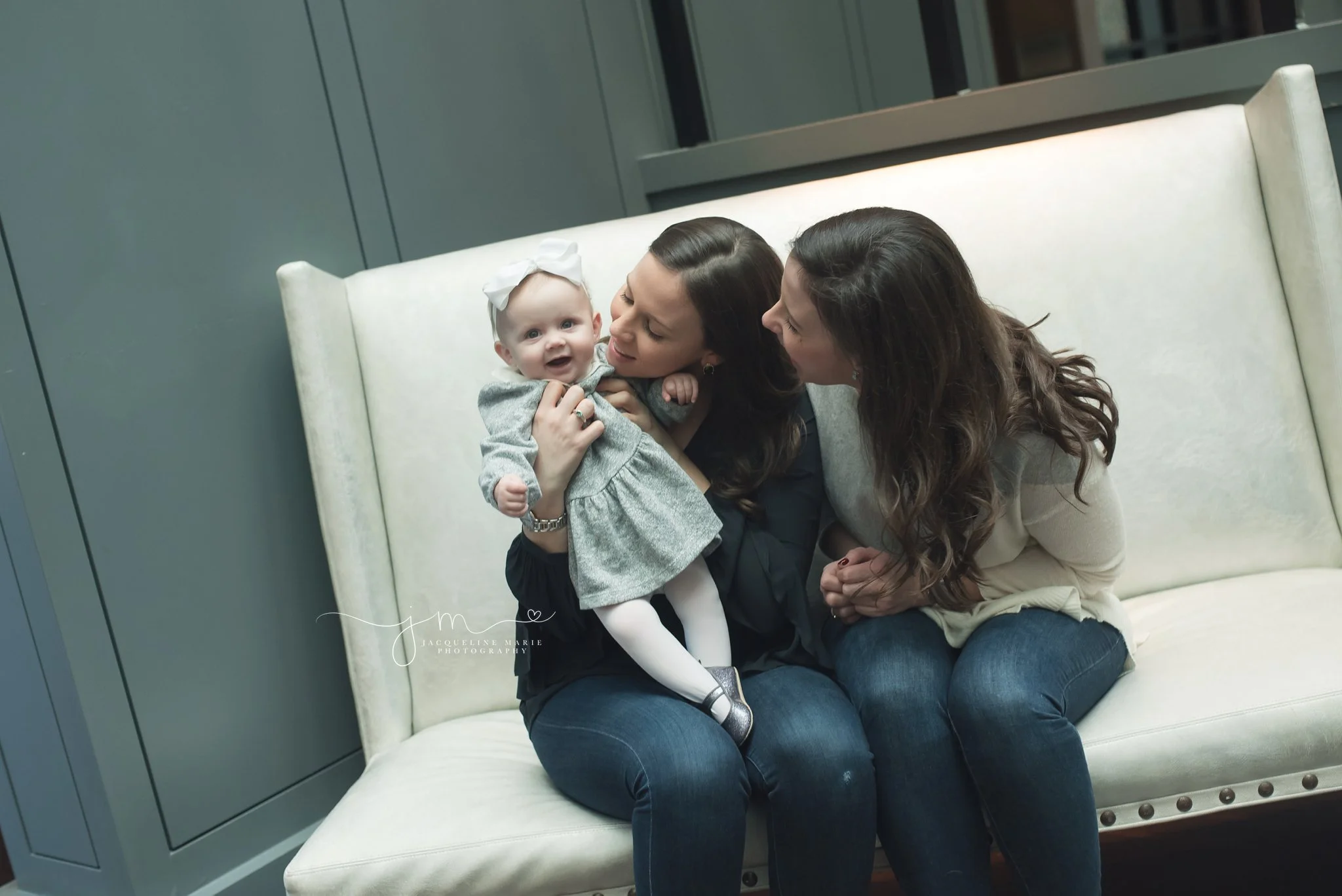 columbus ohio photographer features image of 6 month old baby girl smiling while she is being held by her aunts at the Hilton Hotel