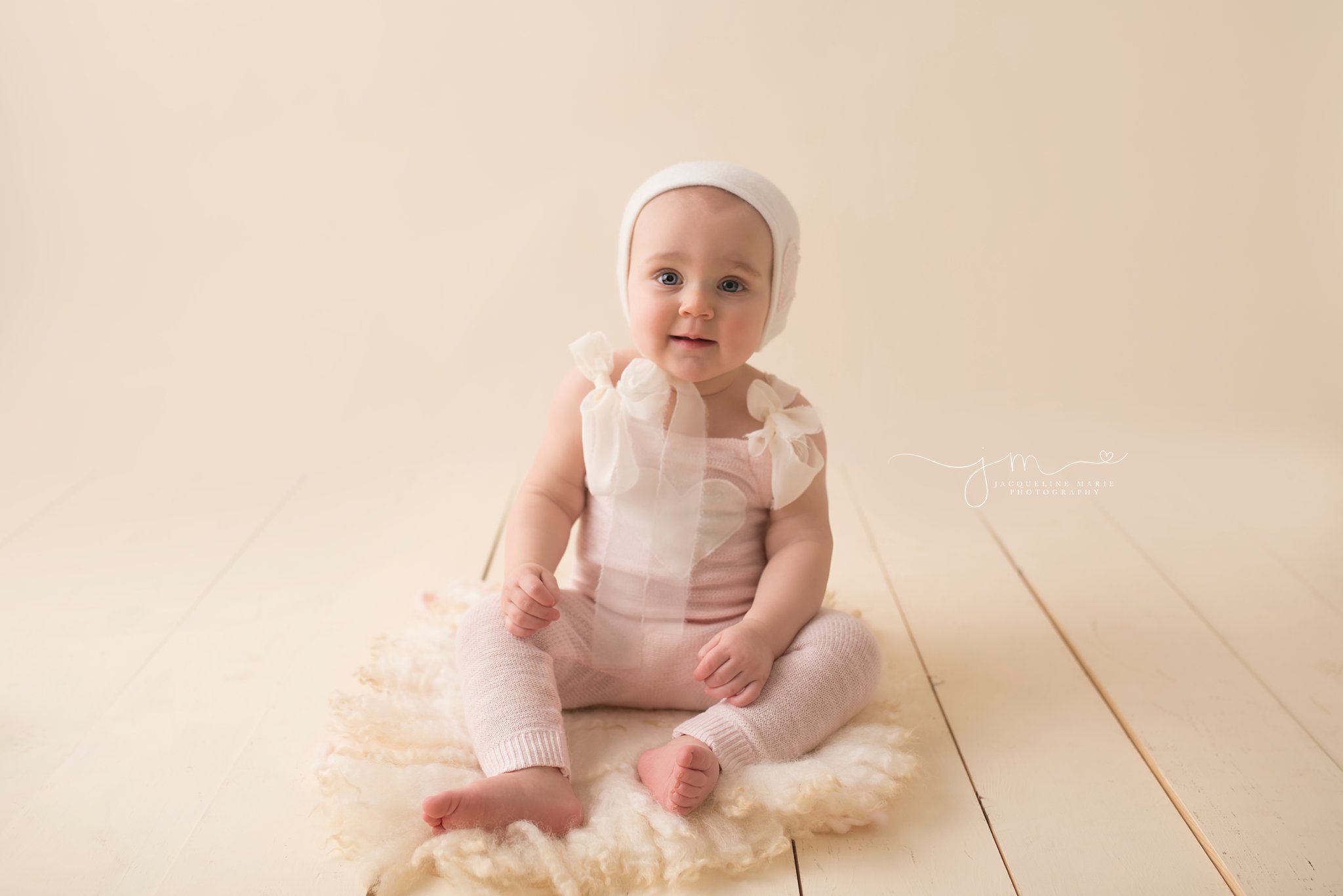 columbus ohio one year old wears pink and cream romper for first birthday pictures