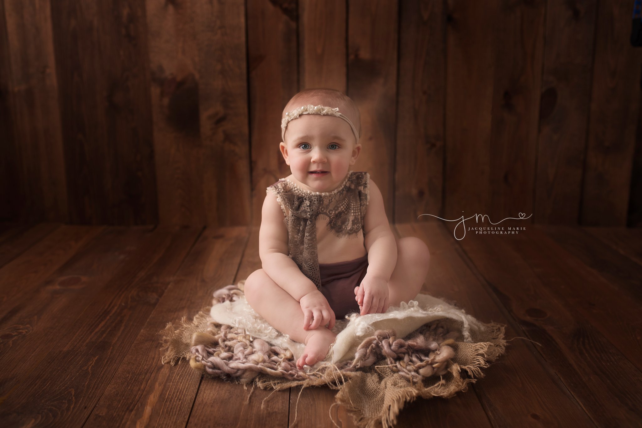 first birthday photographer features baby girl sitting in wood bowl for first birthday pictures in columbus ohio