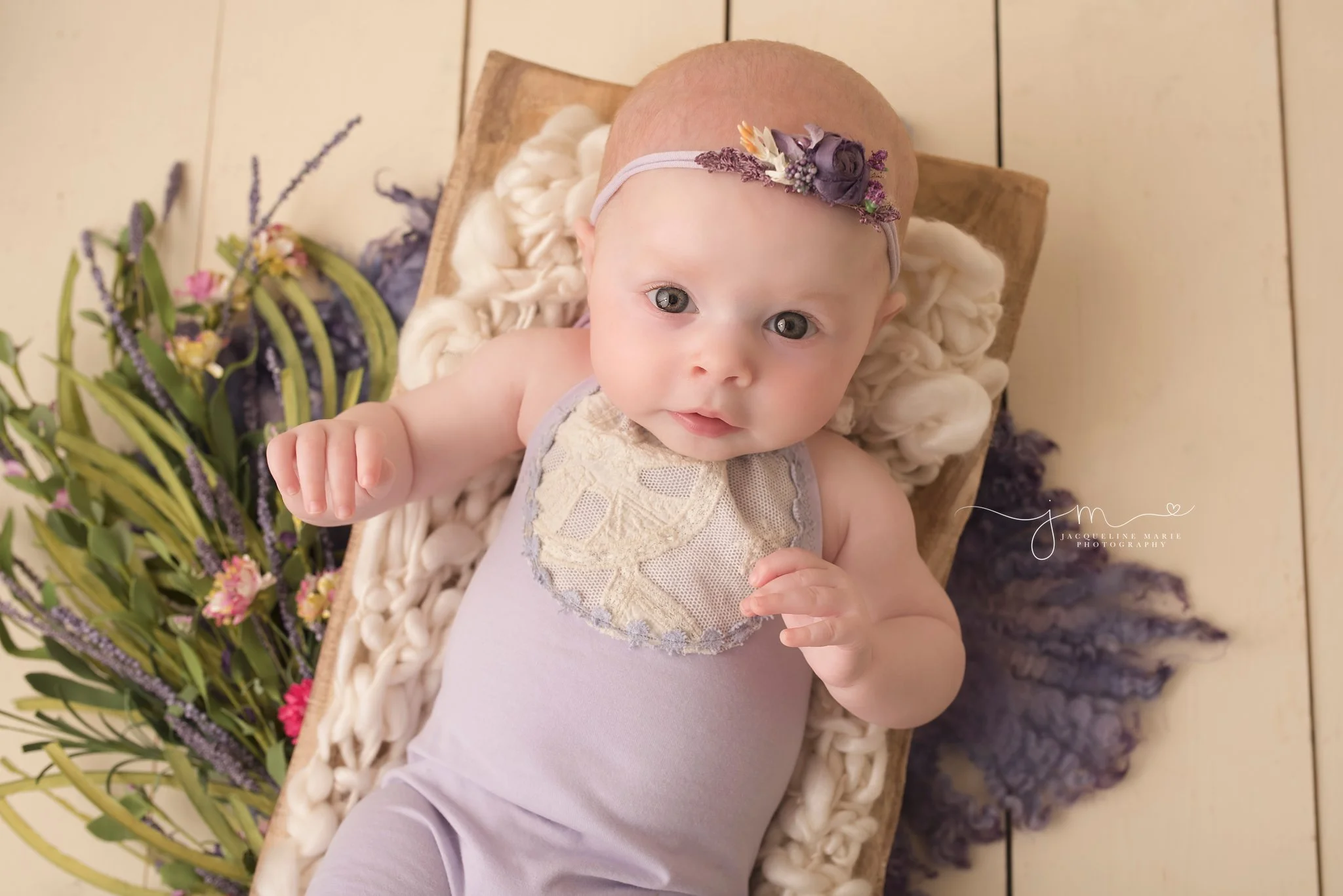 baby girl wears purple romper and matching headband in Columbus ohio for baby pictures