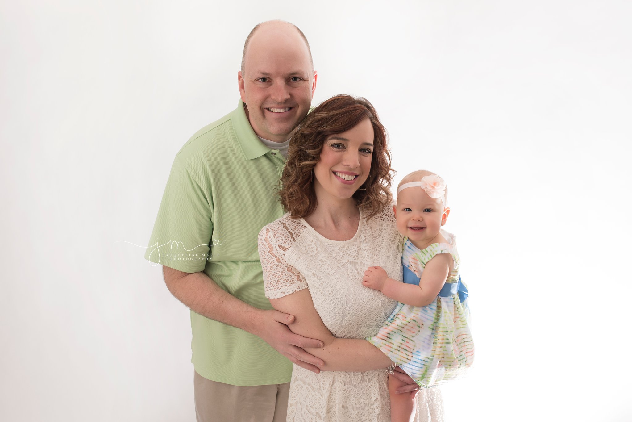 columbus ohio mother and father hold baby girl smiling for baby milestone photography