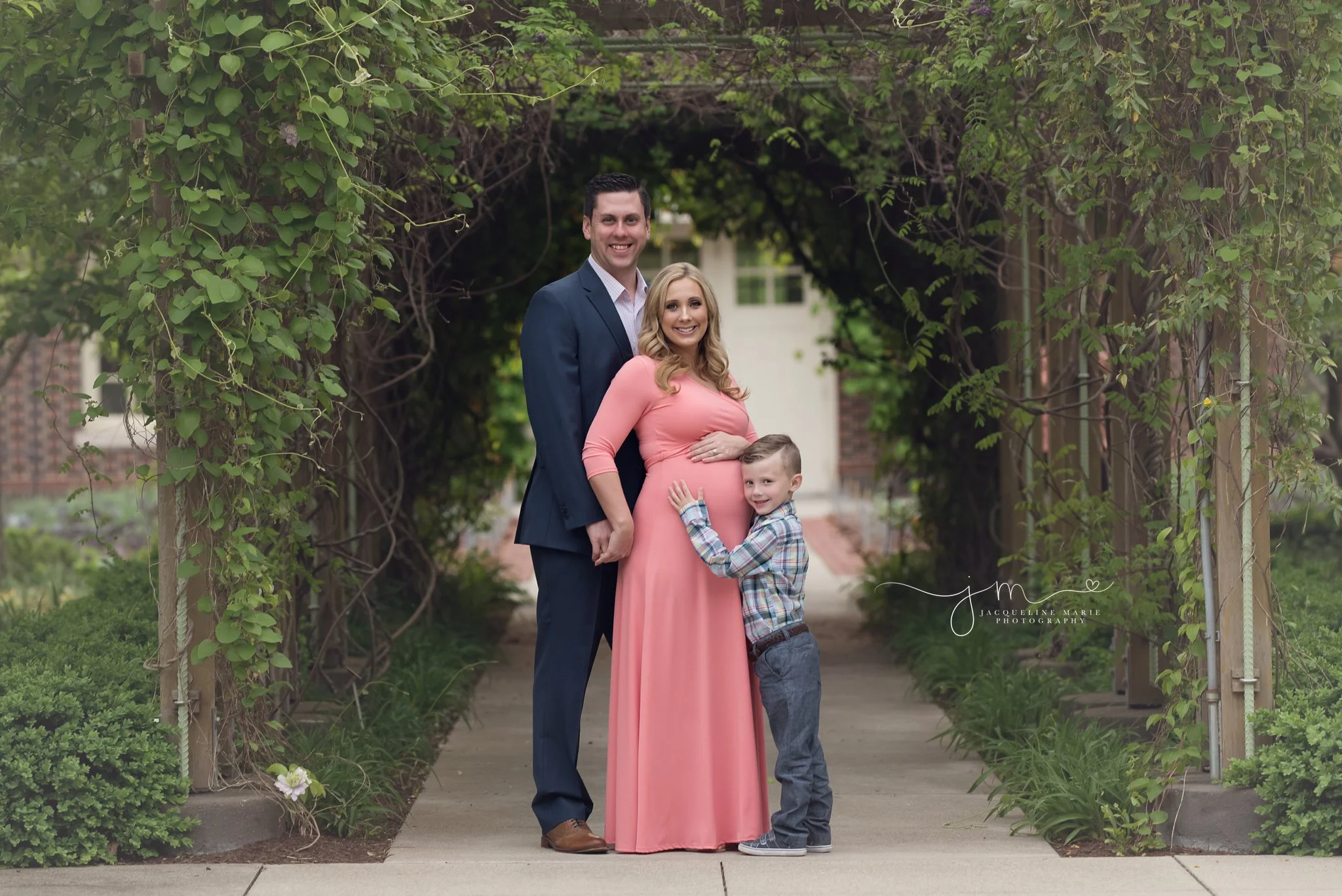 columbus ohio family of three wears blue, navy and coral for maternity and family pictures at franklin park conservatory by jacqueline marie photography