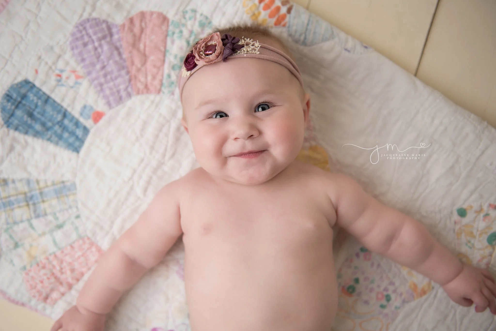 columbus ohio baby lays on vintage built and wears floral headband for 6 month milestone pictures
