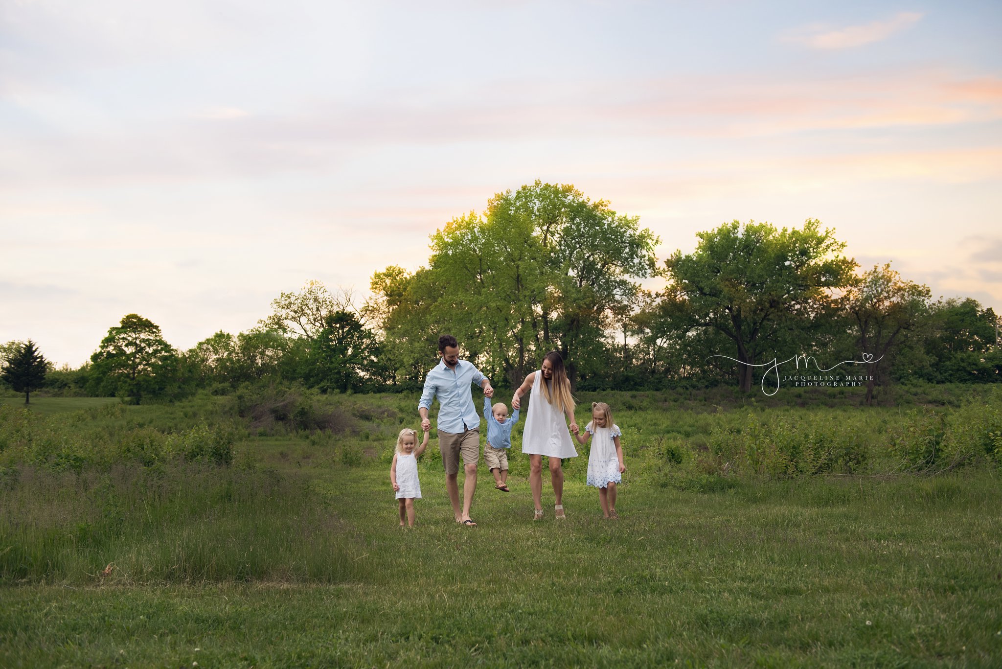 columbus ohio family of five walks at sunset in a park holding hands for family photography session with jacqueline marie photography 