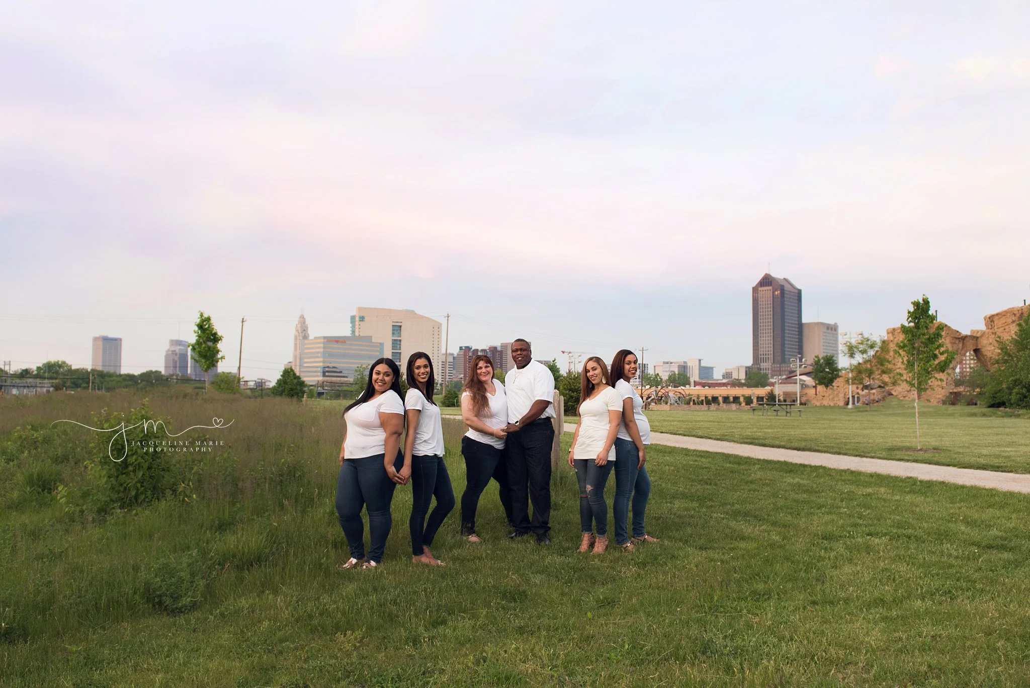 family photographer in Columbus ohio features family poses with columbus skyline