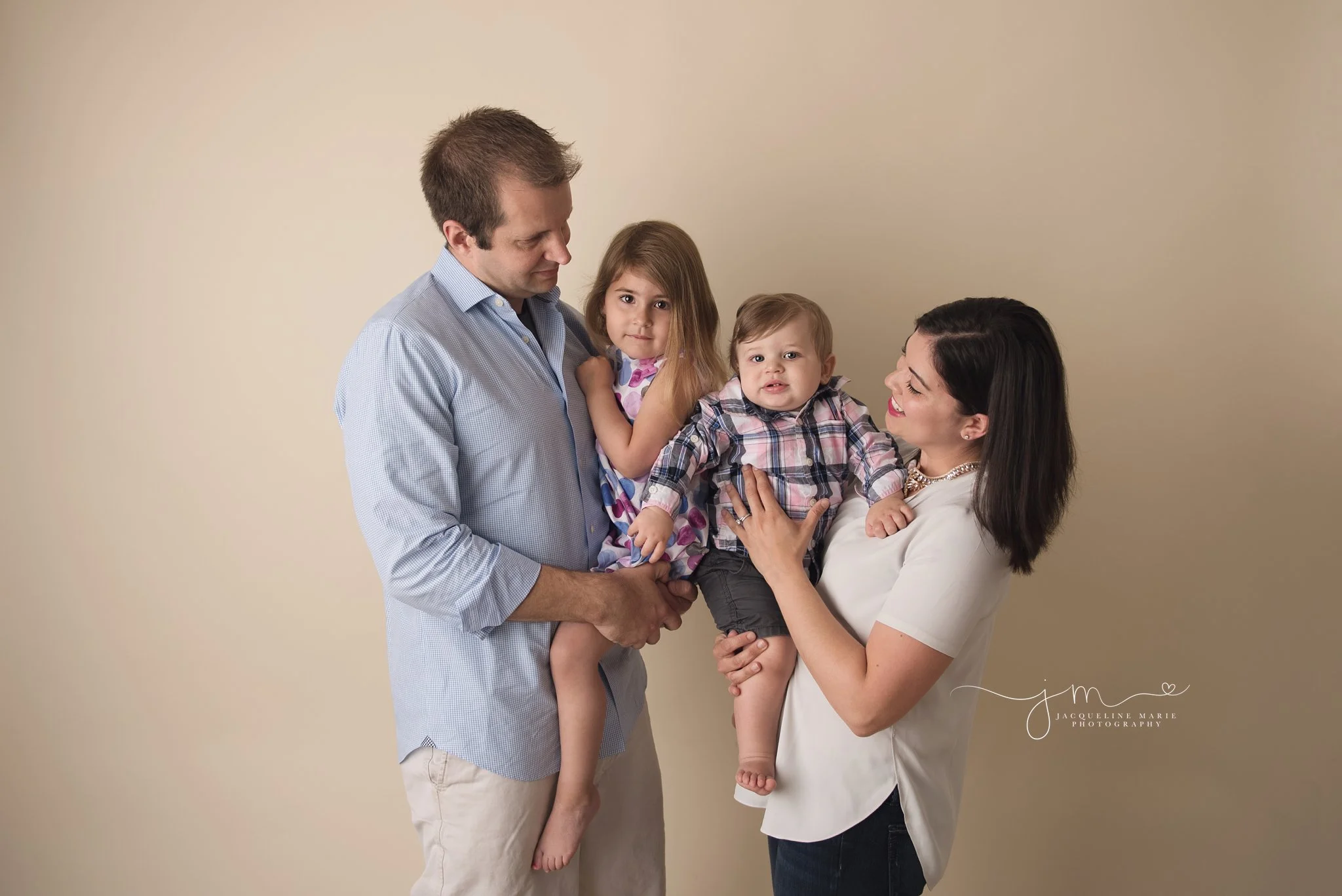 family of four portrait features mother and father holding son and daughter in columbus ohio