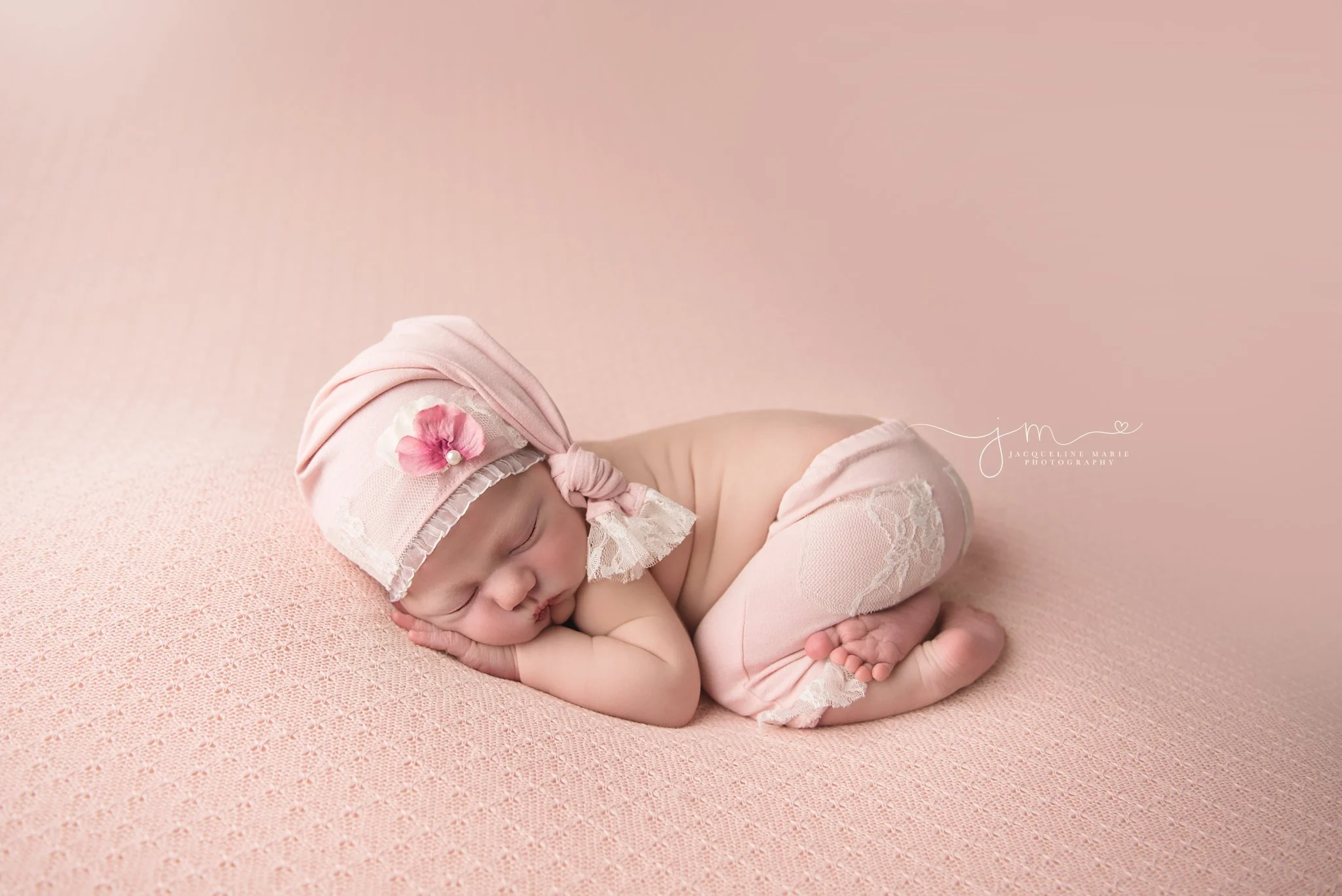 columbus ohio newborn baby girl wears pink hat with lace and flower for newborn photography portraits