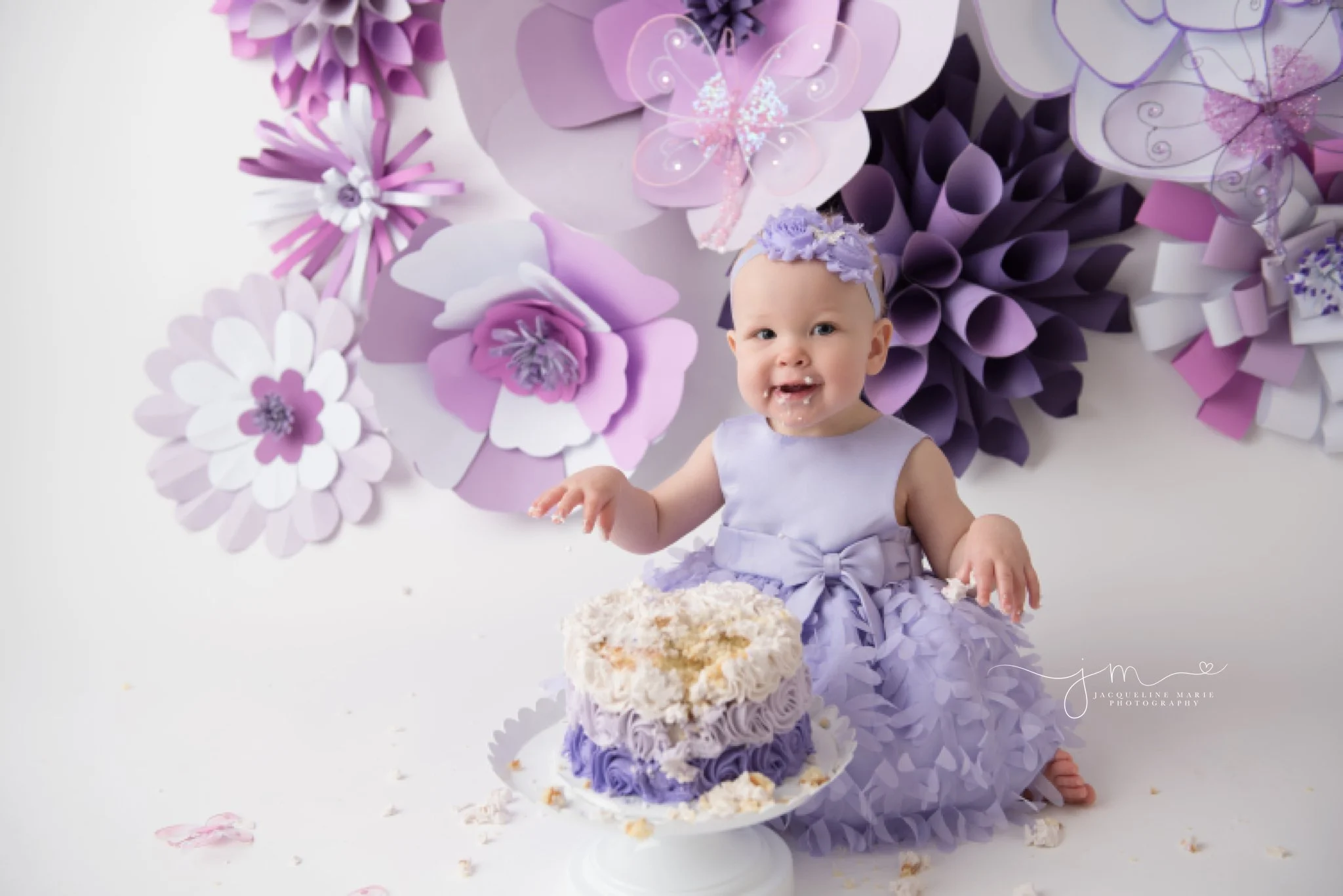 first birthday cake smash session with purple paper flowers in columbus ohio