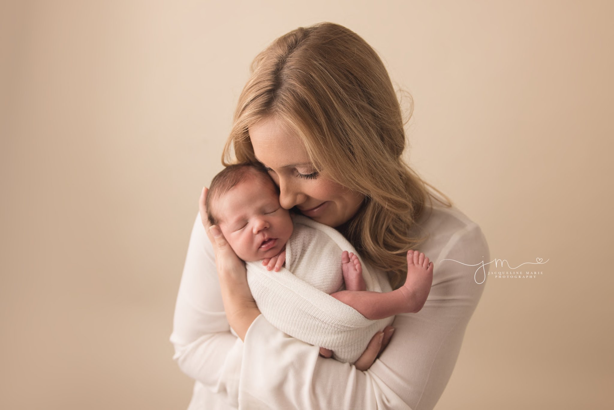 columbus ohio newborn photographer feature image of mother holding son and showing love by smiling at him