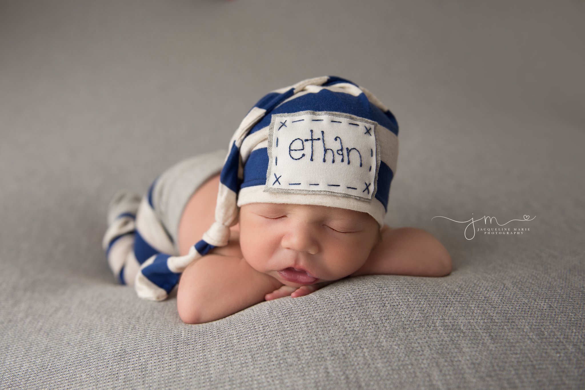 2 week old newborn baby boy wears stripe hat and pants for newborn photography pictures in columbus ohio