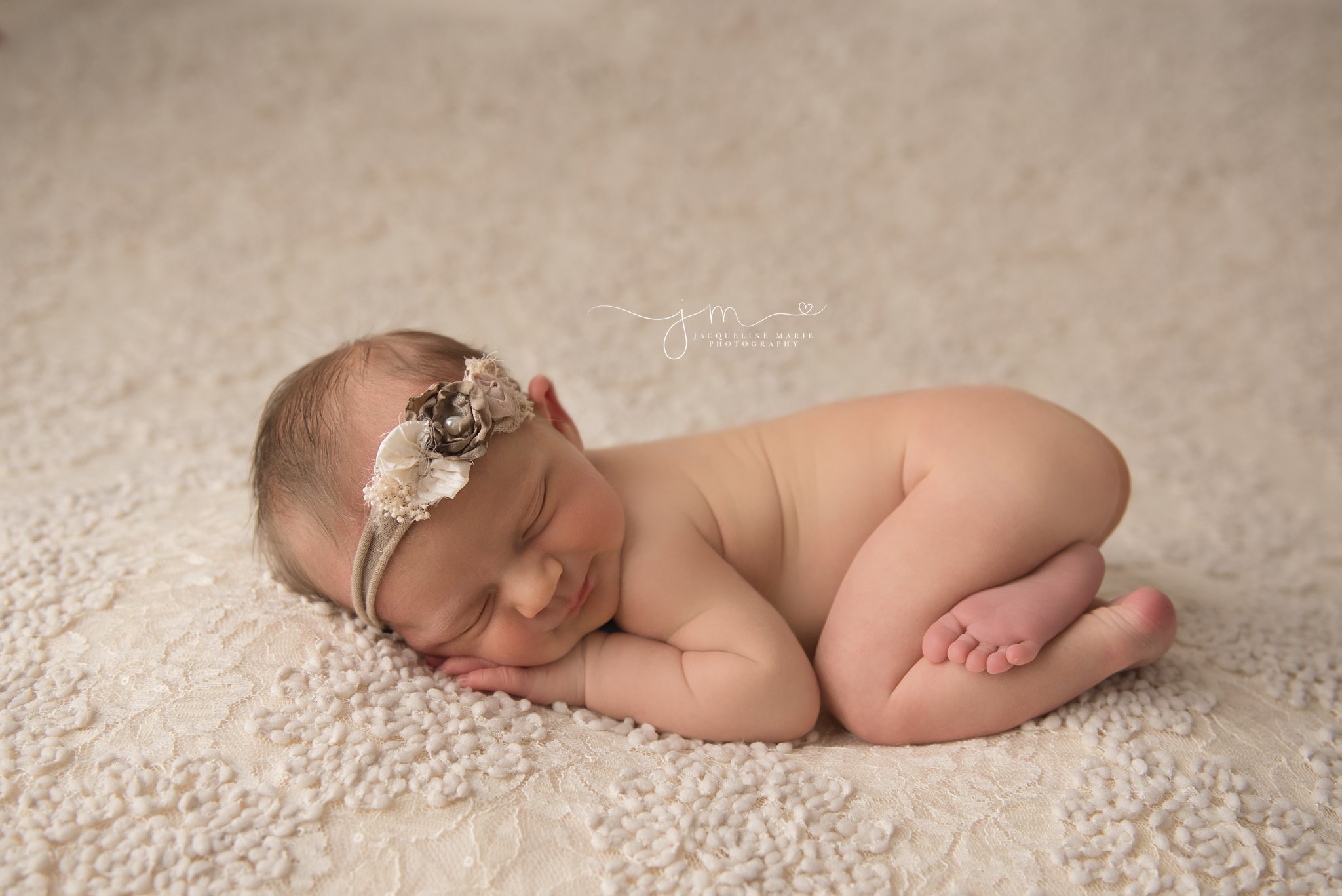 columbus ohio newborn photographer features images of newborn baby girl wearing neutral floral headband while smiling 