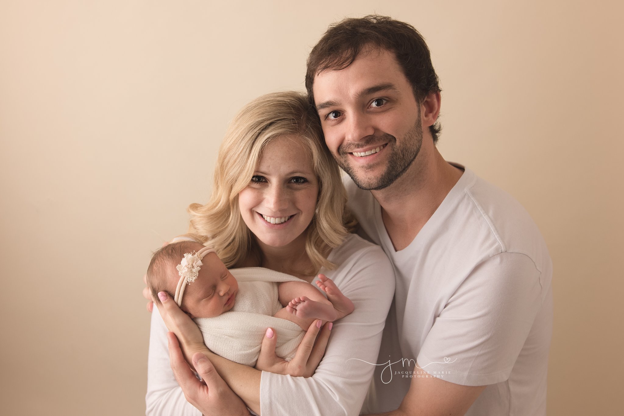 mother and father hold newborn baby girl girl at jacqueline marie photography studio in Columbus ohio for newborn photography pictures