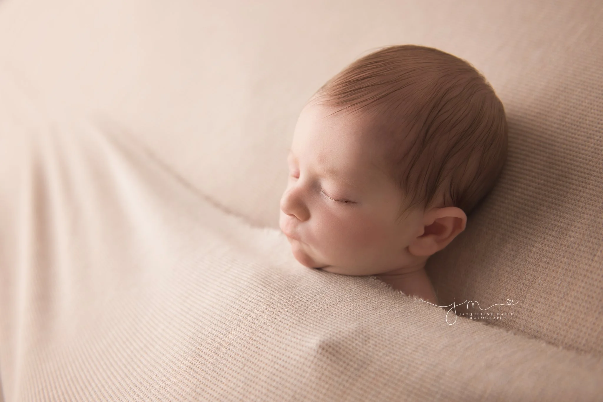 newborn photography portrait features newborn baby boy sleeping on tan blanket in columbus ohio