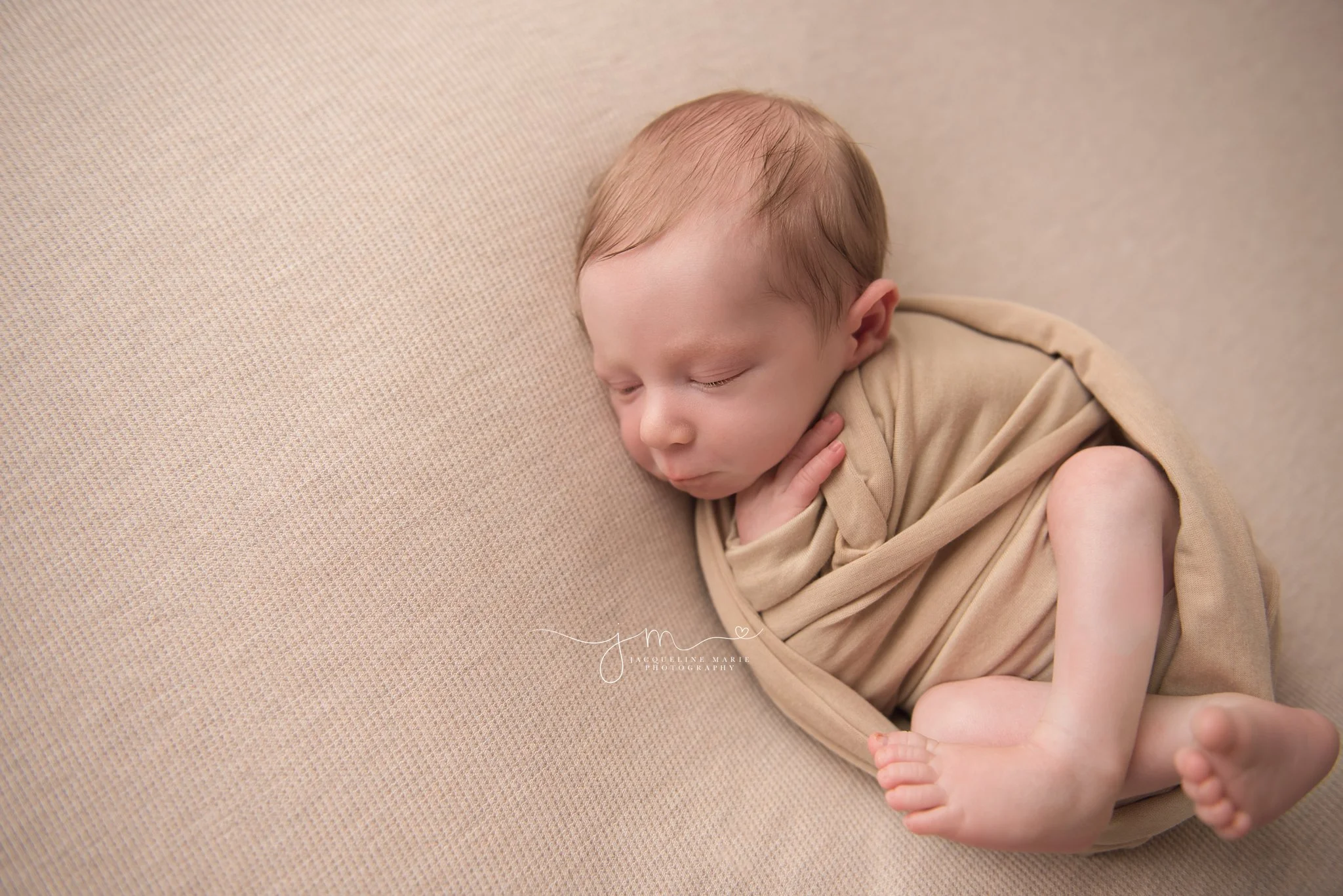 columbus ohio newborn photographer features baby boy wrapped in tan swaddle wrap while sleeping 
