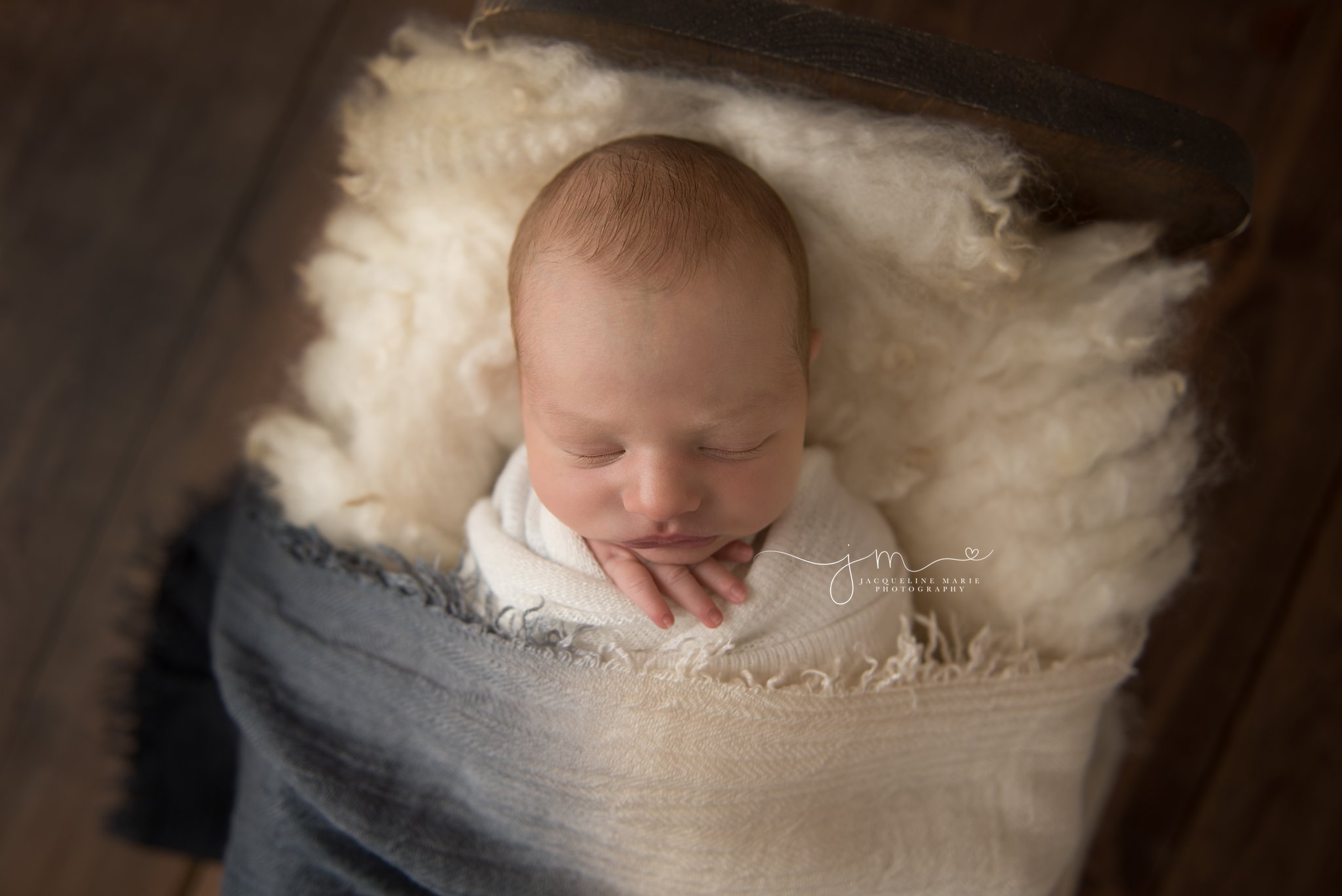 columbus ohio newborn photographer features image of baby boy sleeping is wood bed for newborn photography session
