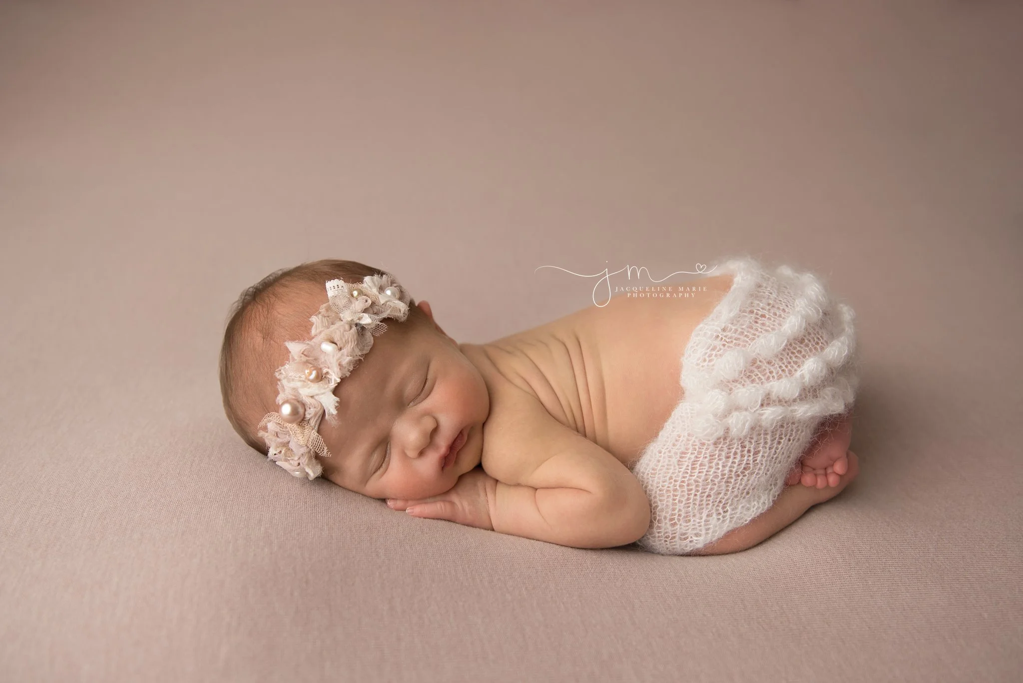 1 week old newborn baby girl wears cream ruffle pants for newborn pictures in columbus ohio