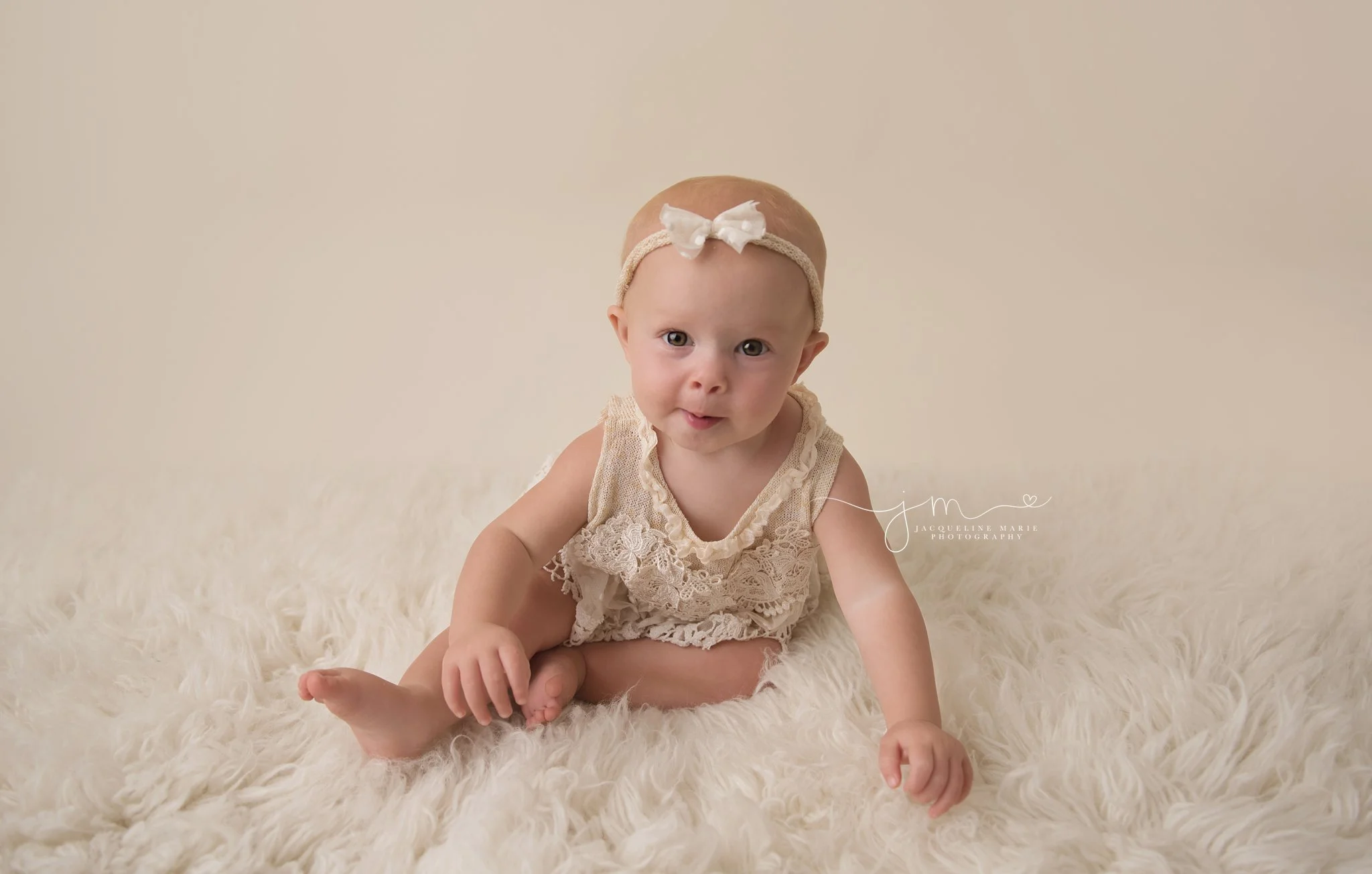 1 year old girl wears cream lace romper for first birthday pictures in columbus ohio