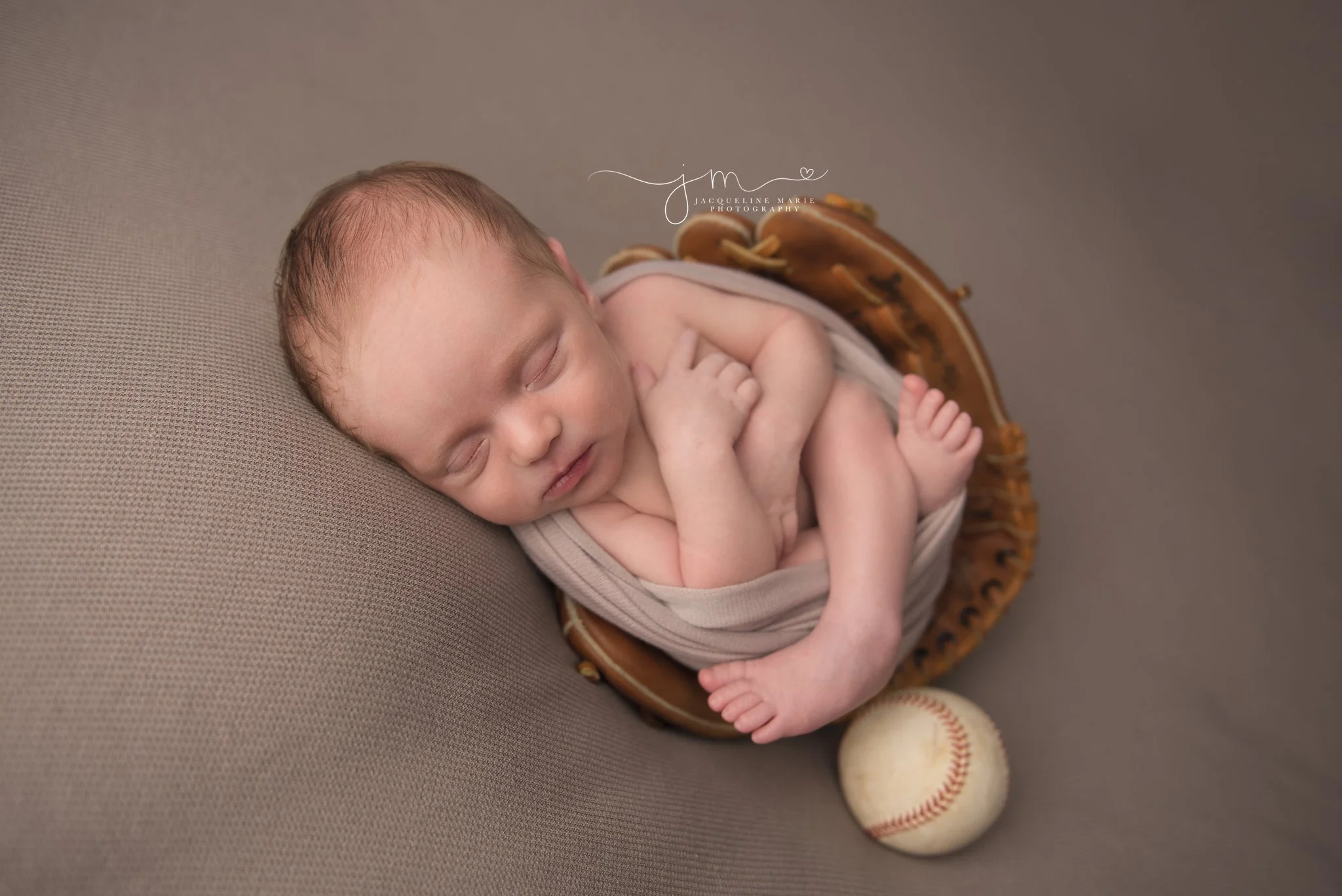 columbus ohio newborn photographer features images of newborn baby boy sleeping is dad's baseball glove