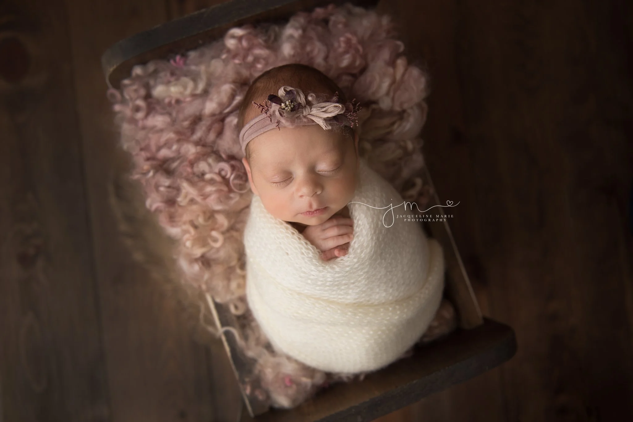 columbus ohio newborn photographer features images of baby girl swaddled in cream wrap while lying in wooden bed