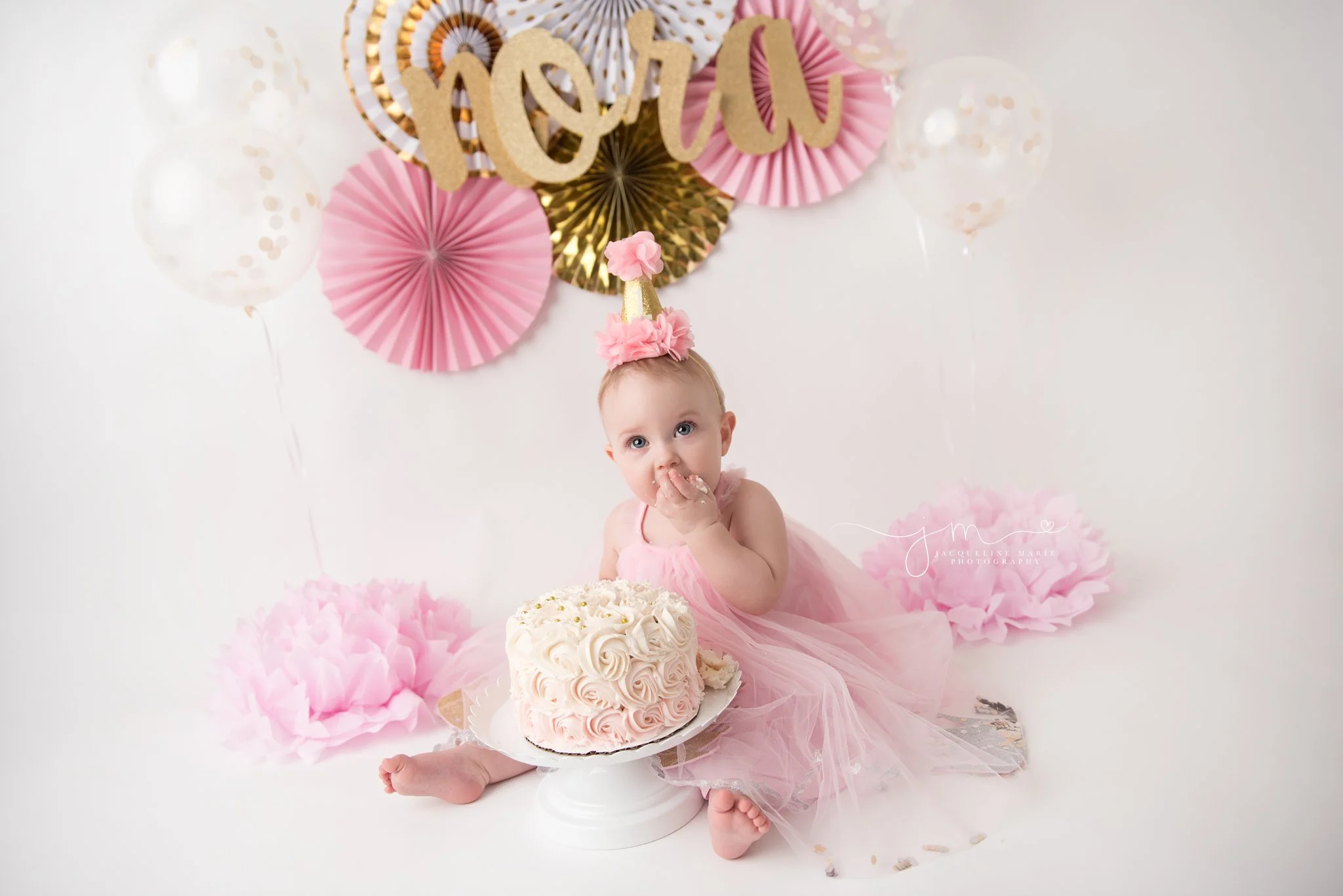 1 year old girl eats pink and cream cake for her cake smash session in columbus ohio