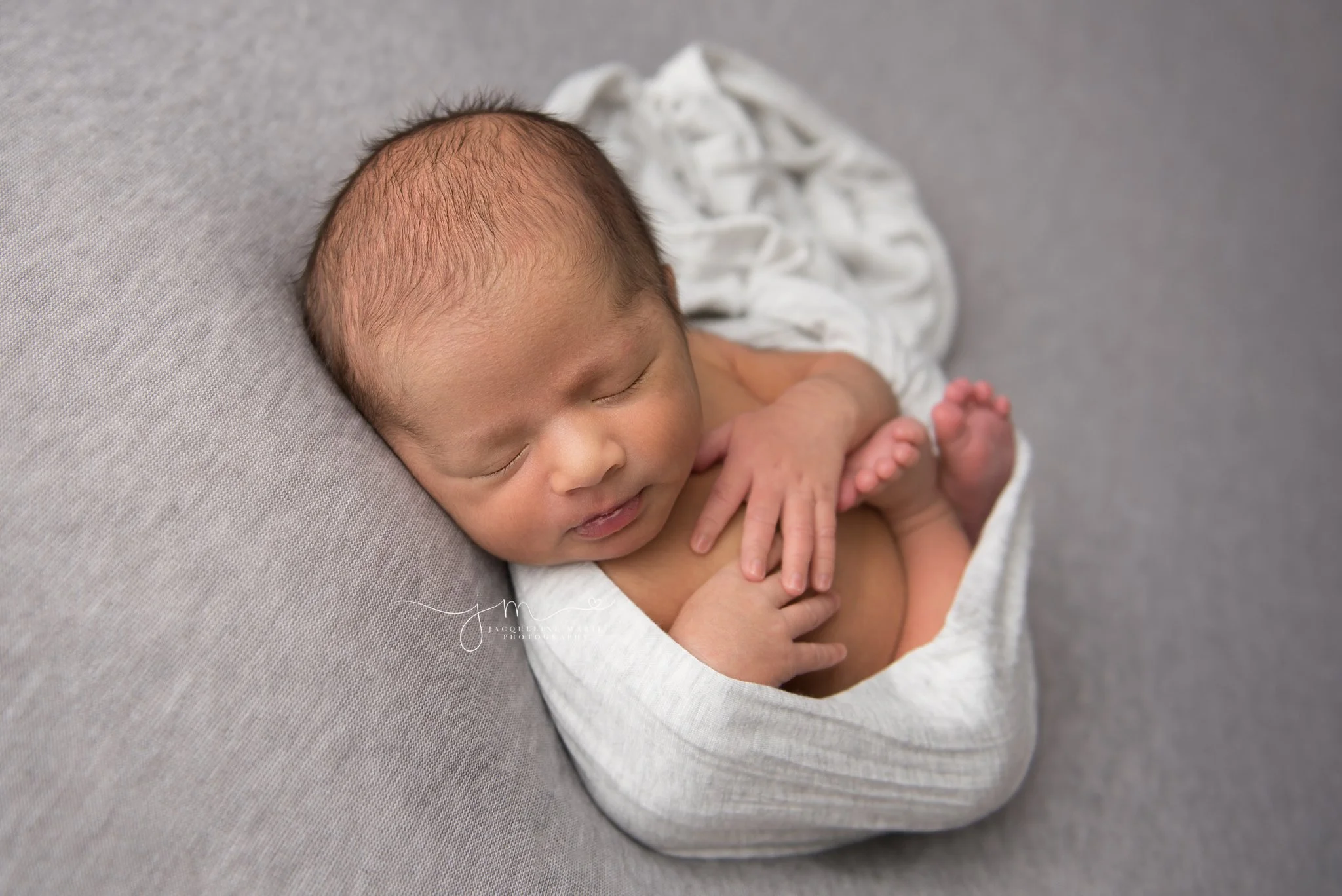 columbus ohio newborn photographer features images of baby boy wrapped with hands on chest
