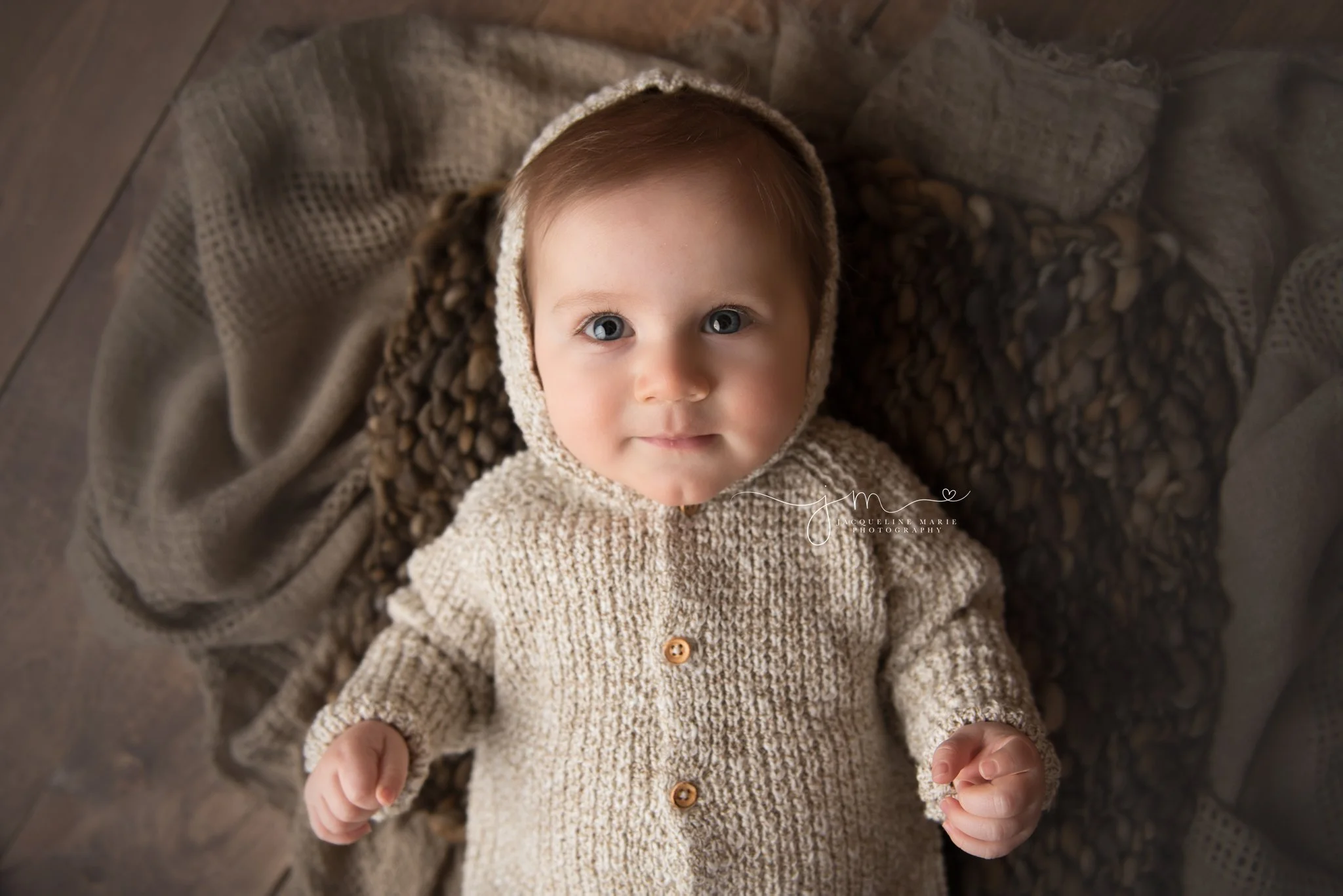 columbus ohio 6 month old baby boys wears hooded sweater at photography studio for milestone pictures