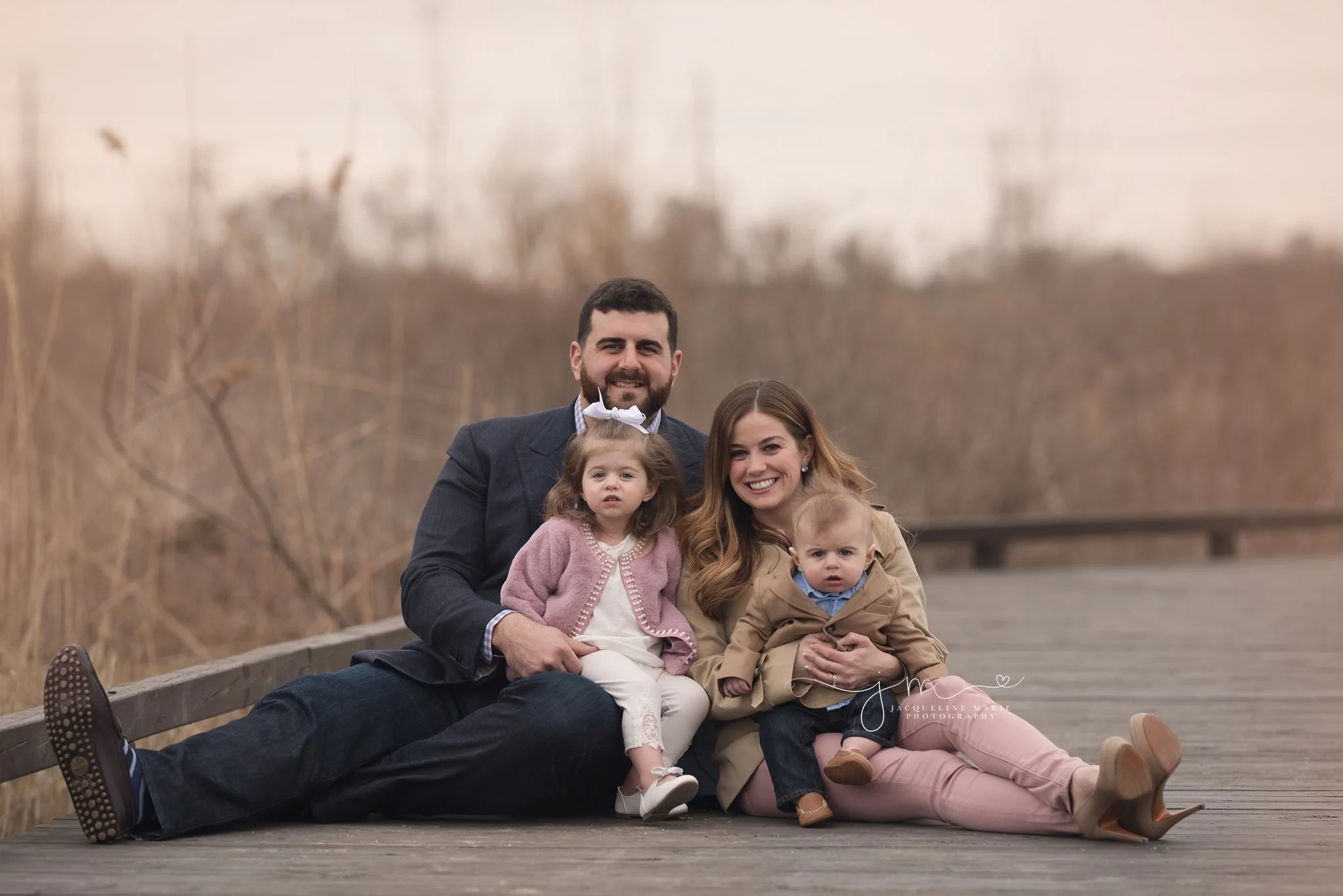 mother and father hold children on wooden bridge in columbus ohio for family portraits 