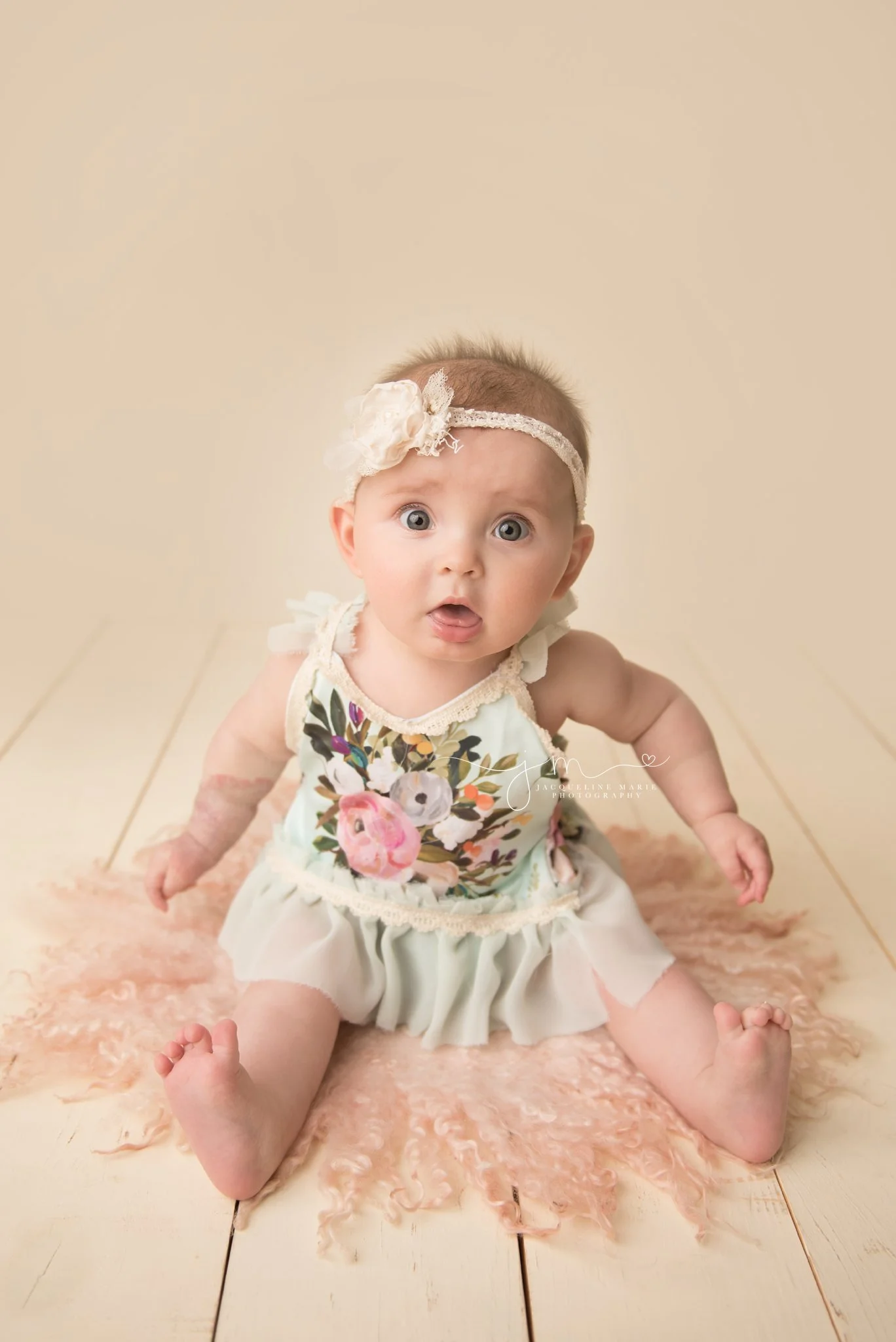 6 month old amelia wears floral romper in columbus ohio for milestone baby portraits