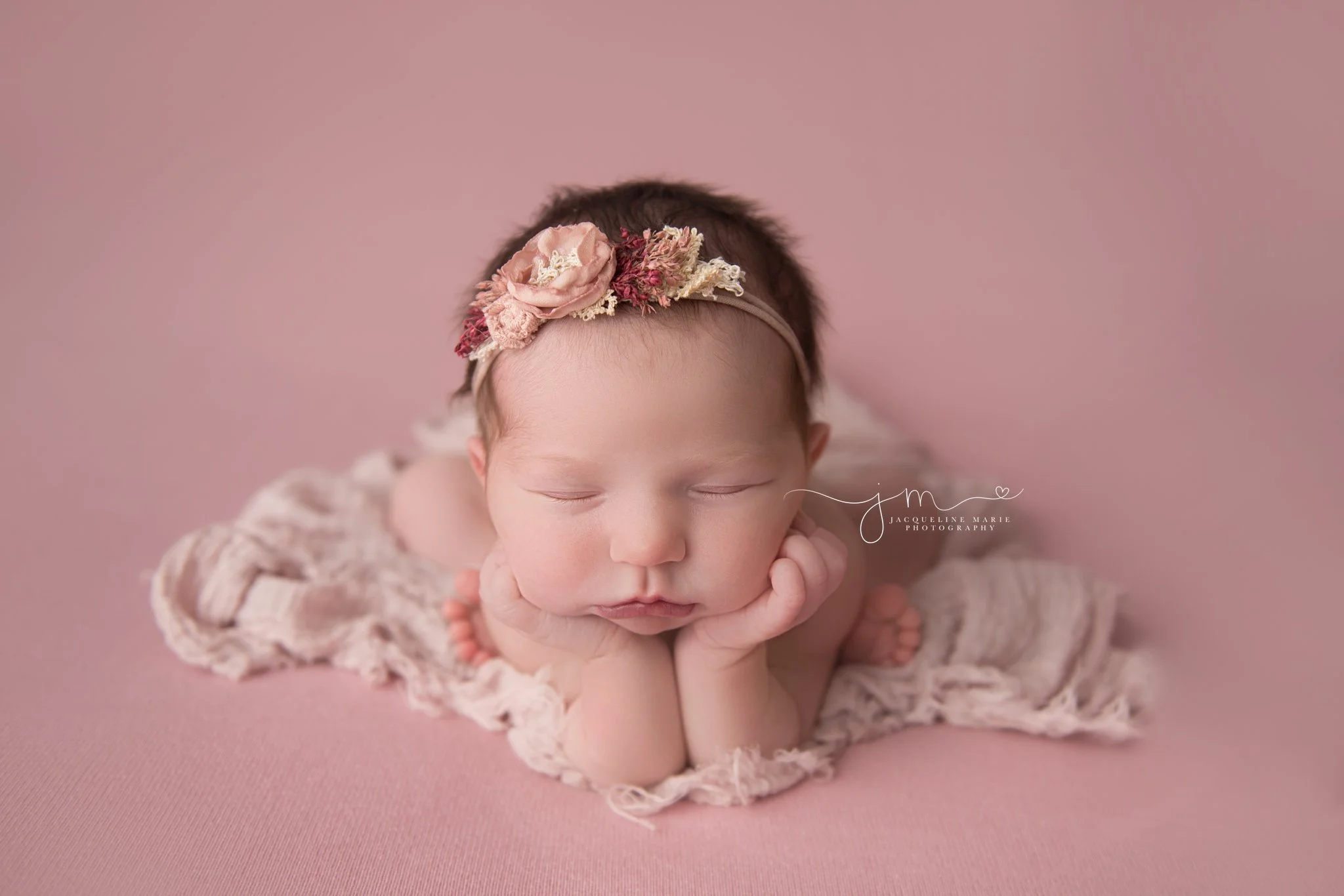 columbus ohio newborn baby girl wears pink floral headband for newborn pictures