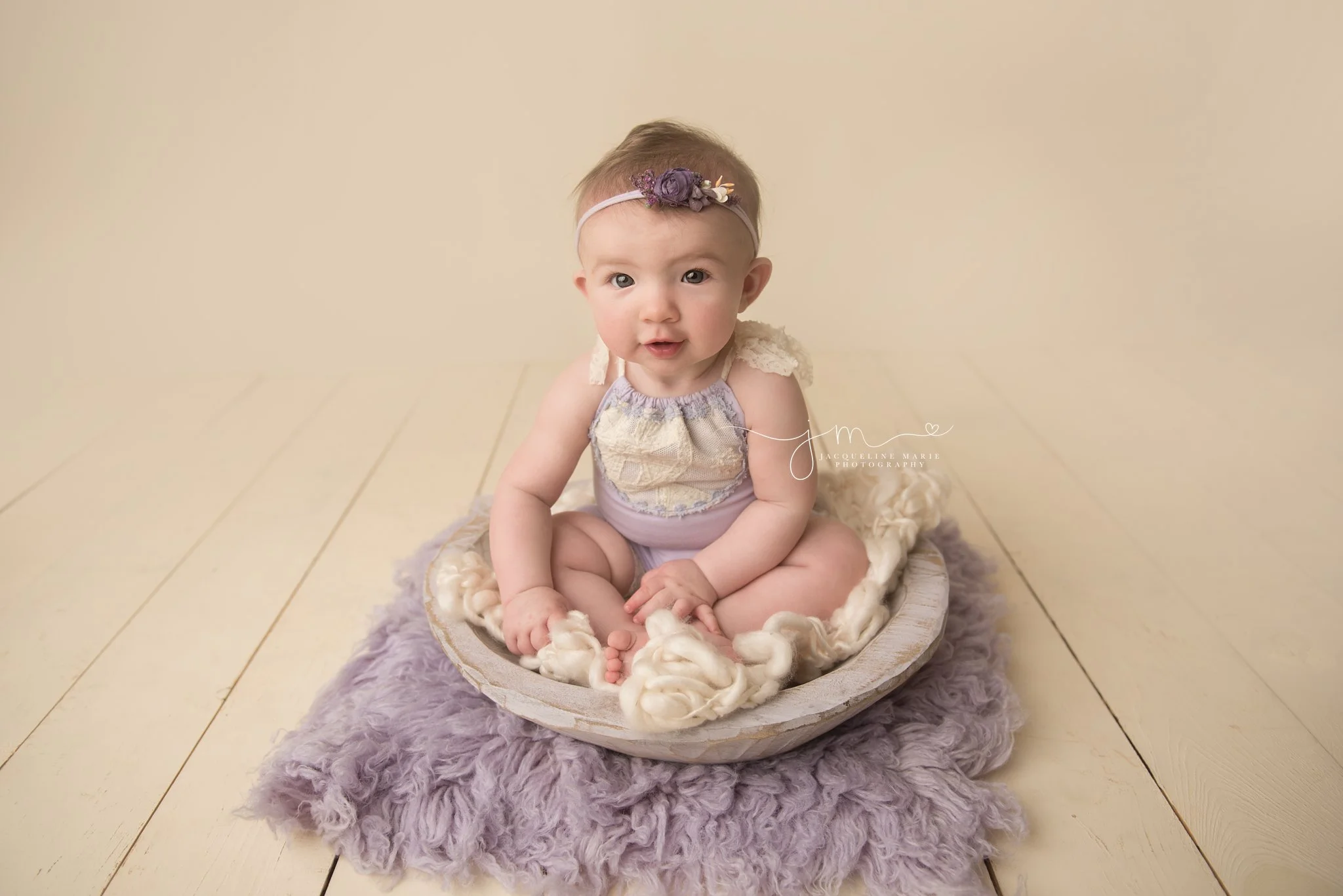 5 month old baby girl wears lilac and lace romper for baby pictures in columbus ohio studio