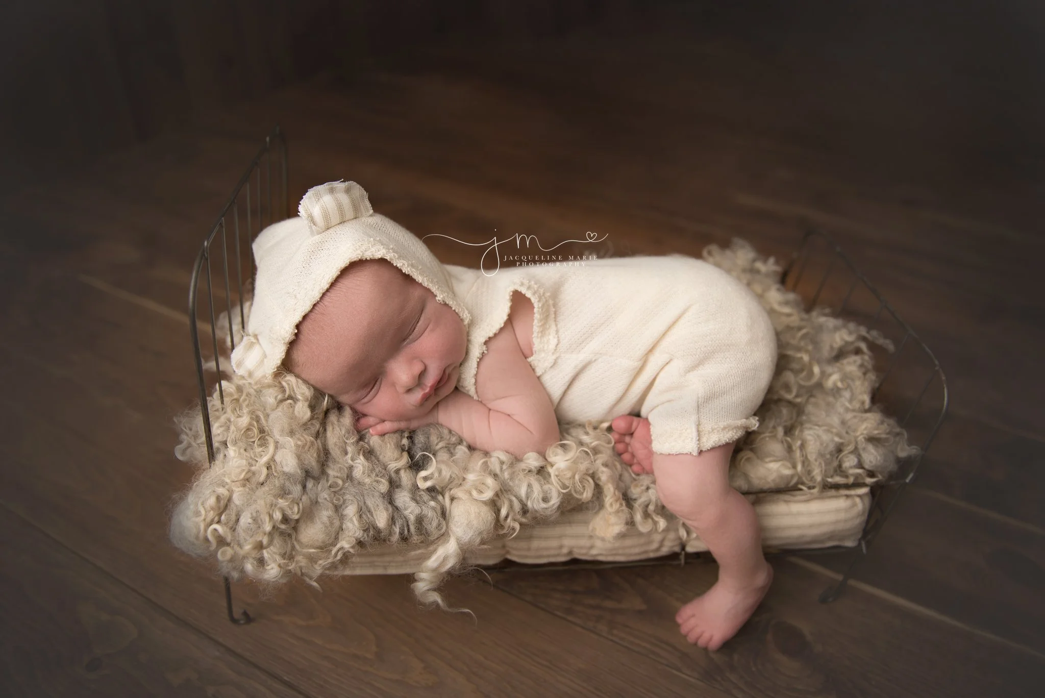 columbus ohio newborn photographer poses baby boy in cream teddy bear romper