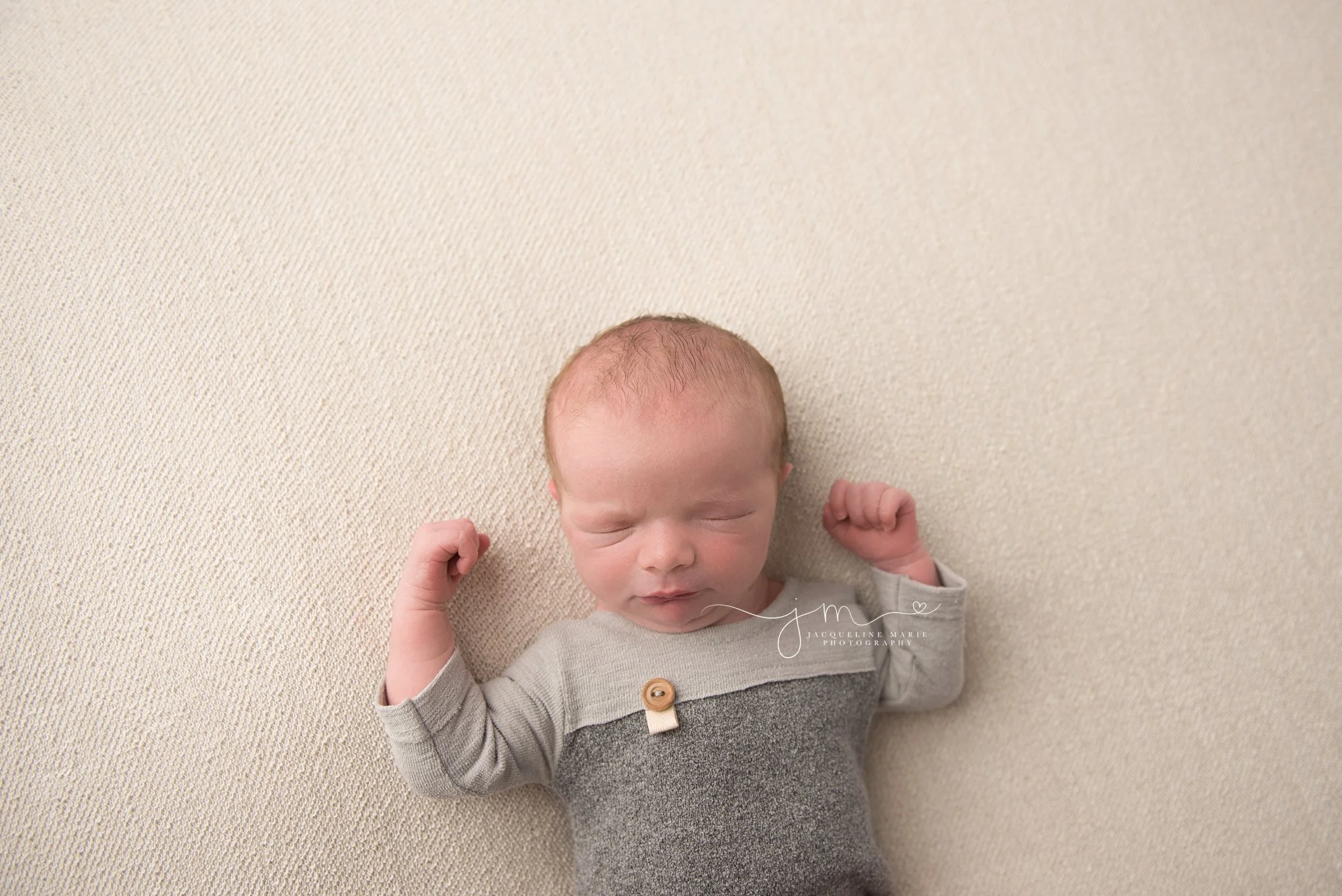 columbus ohio newborn baby wears gray romper during newborn photo session
