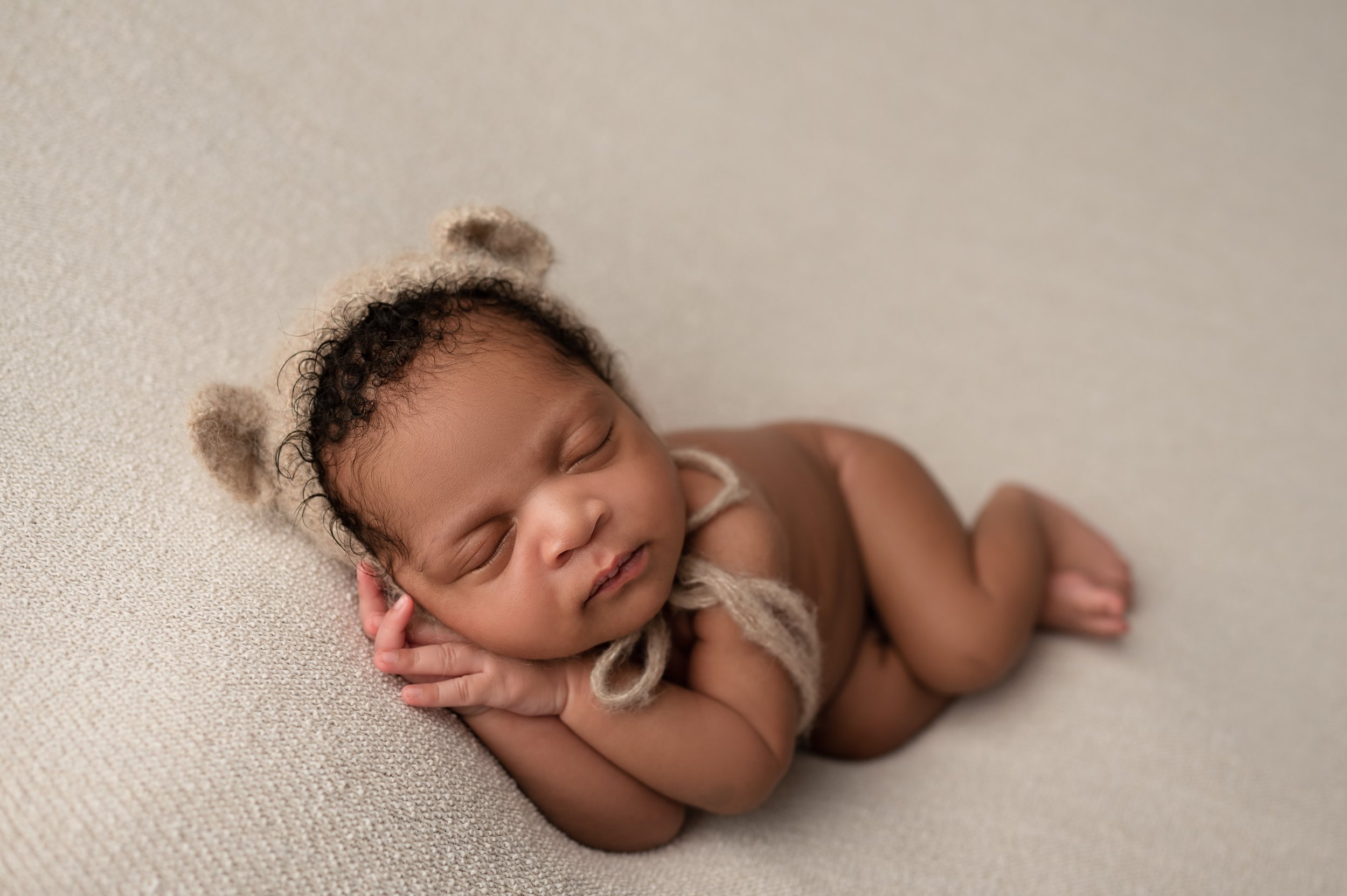 newborn baby boy wears teddy bonnet for newborn photography in columbus ohio