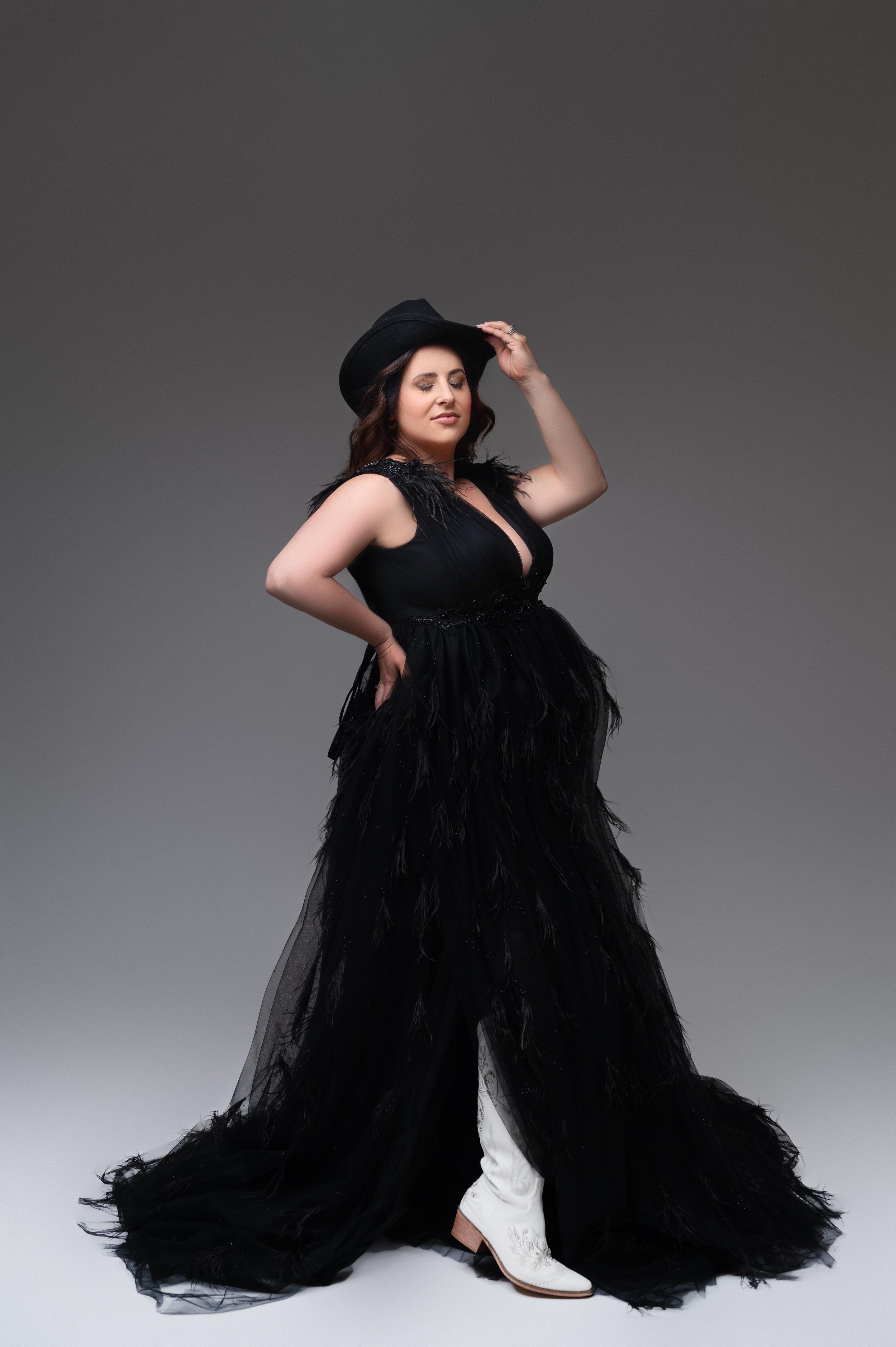 pregnancy photo wearing cowboy boots and cowgirl hat for columbus ohio maternity photography session