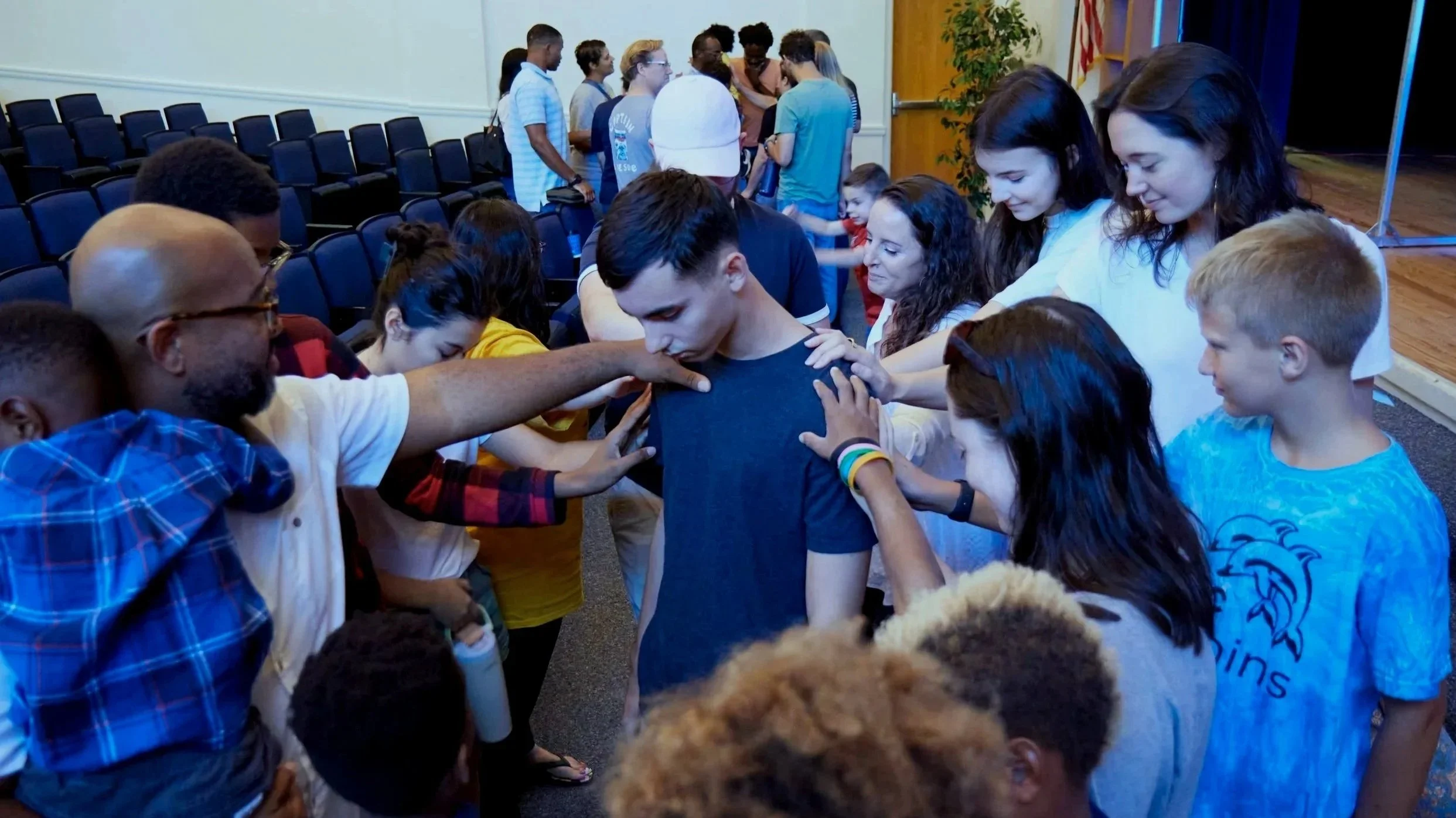 Group of people praying over someone.