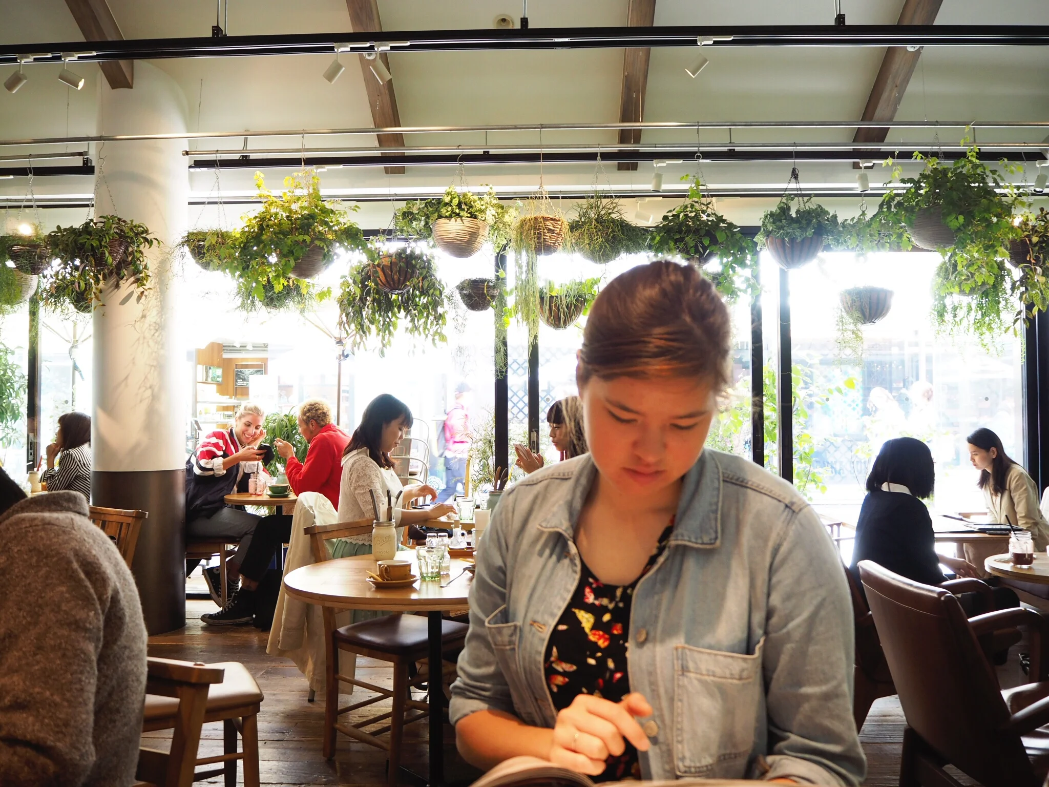 Sister checking out the menu in Hello Farmer, a plant-filled cafe in Shinjuku.