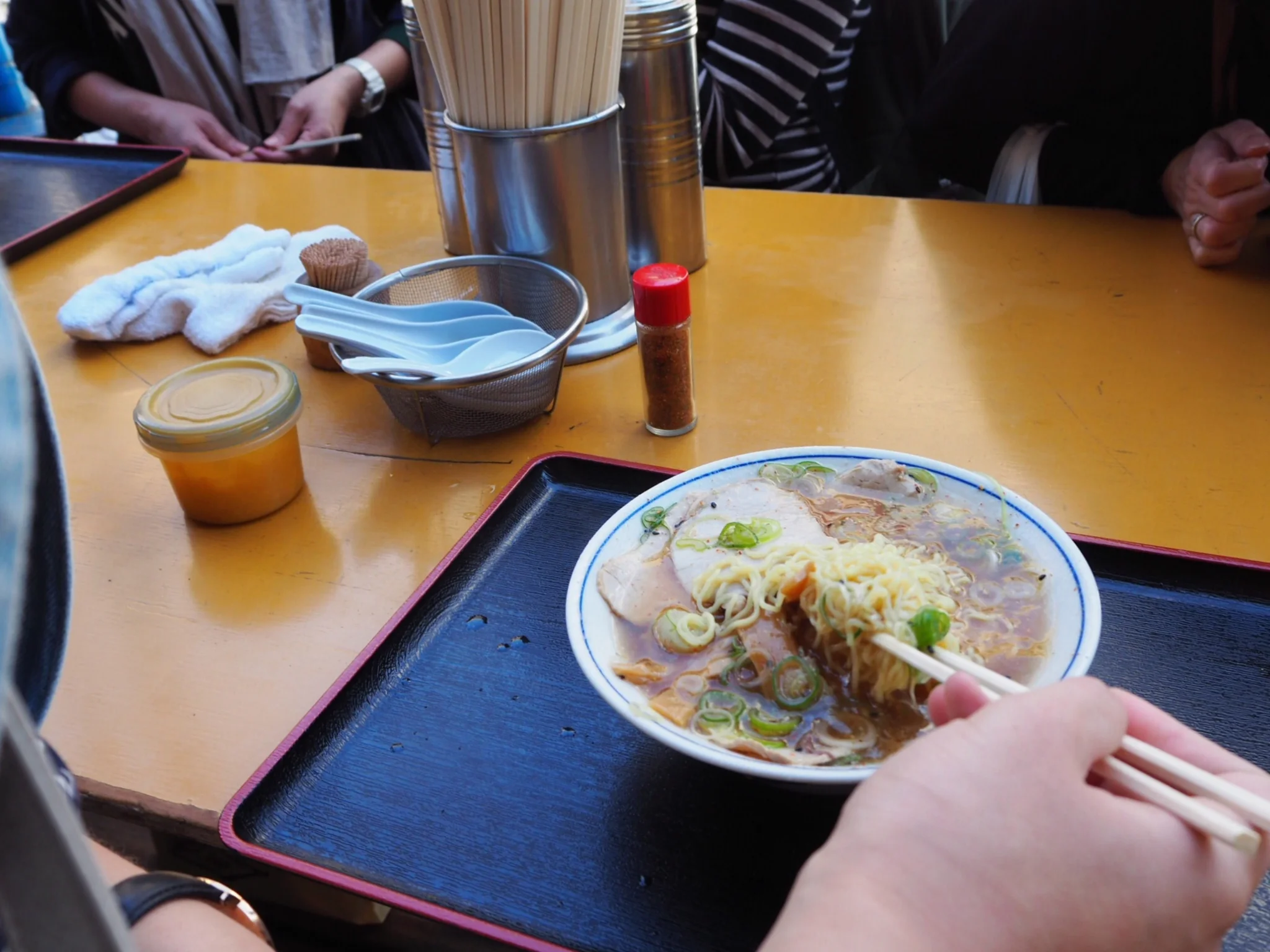 Sister's breakfast ramen on the crowded sidewalk in front of Tsukiji Fish Market