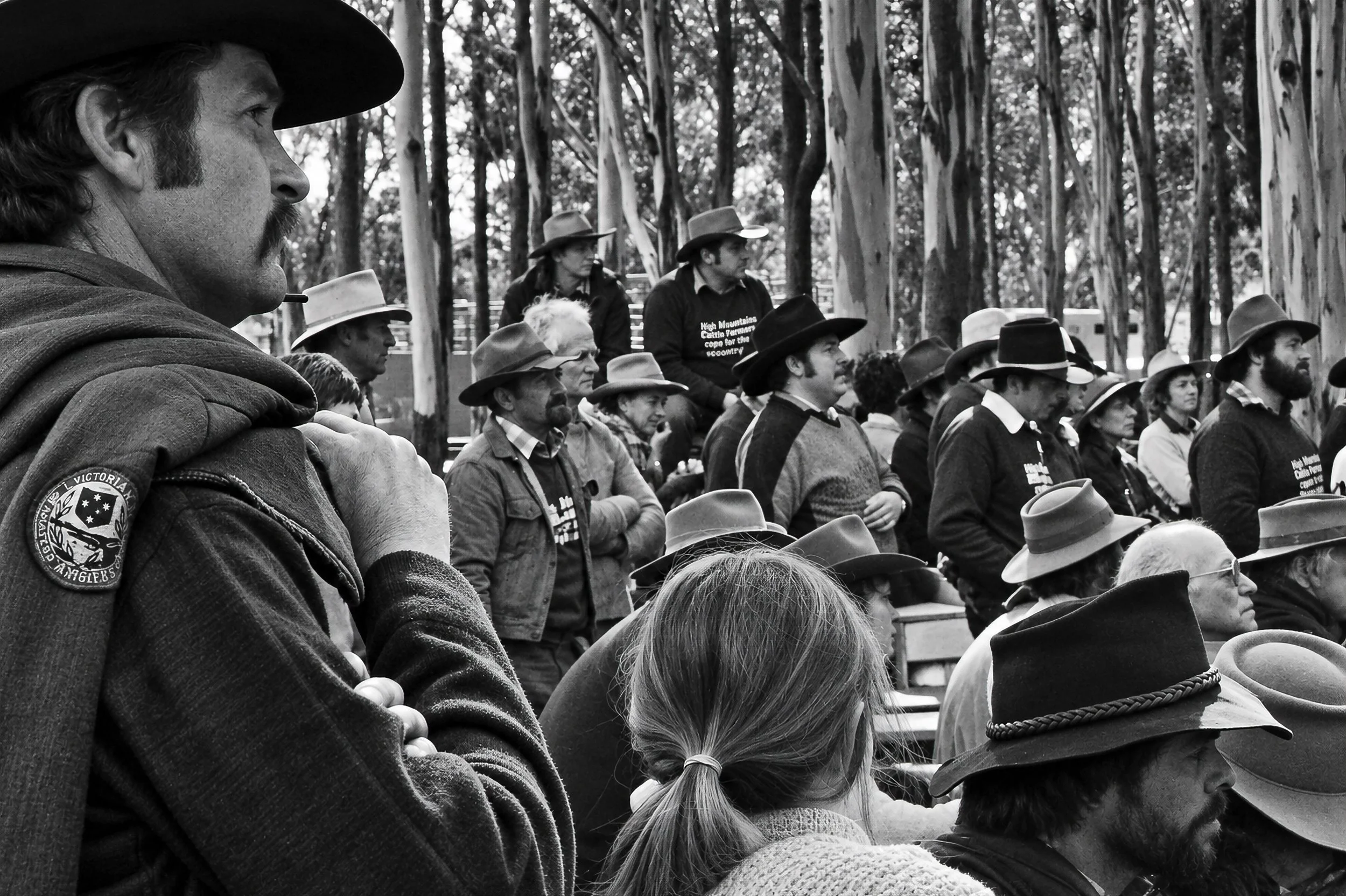 Among the Crowd - A close view into the gathering reveals the faces and characters within the protest. From the man in the foreground to the young girl and the cattlemen behind them, the photograph records the human side of the demonstration.