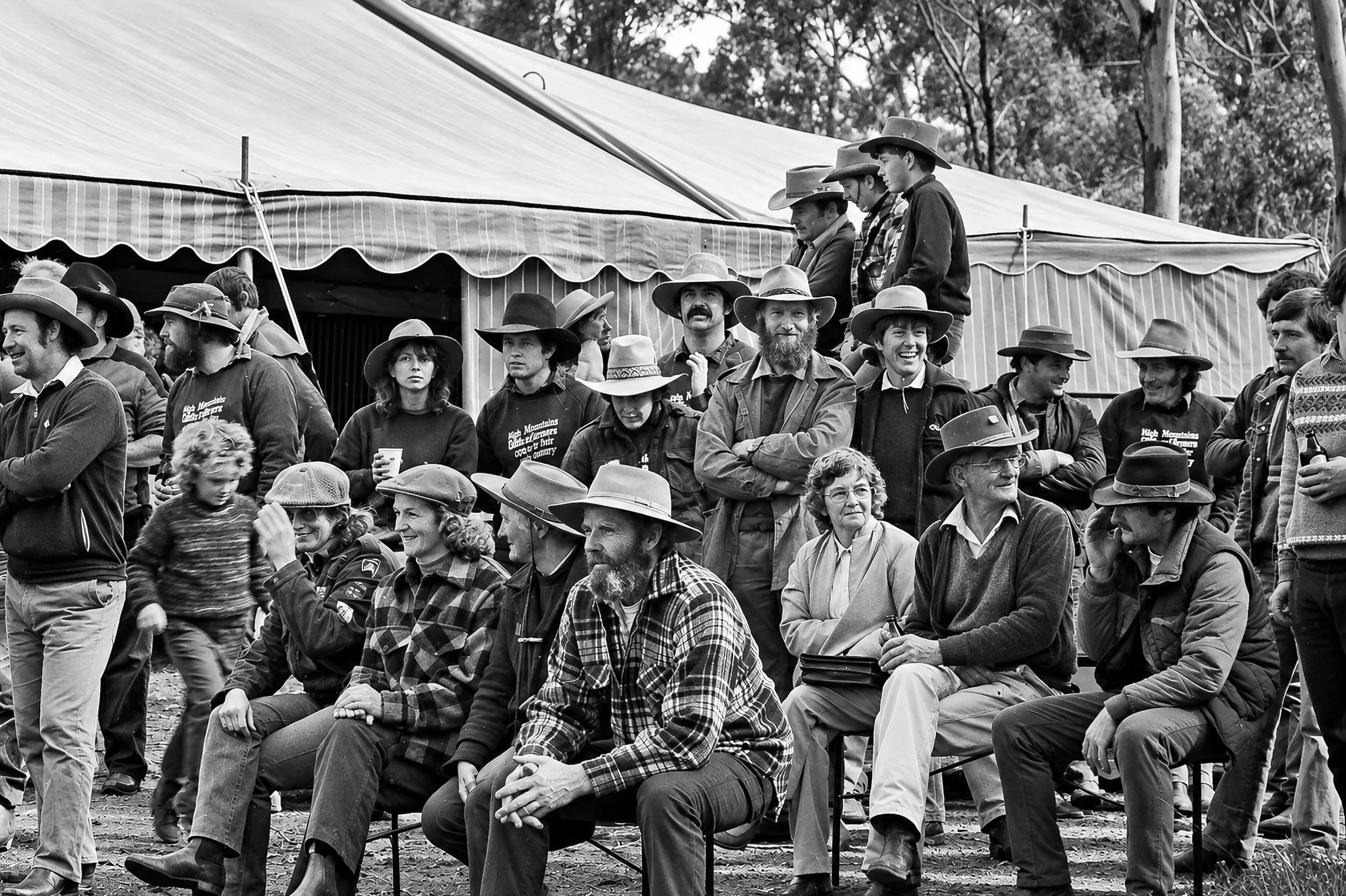 The High Country Gathering - Men, women and children gather in front of the tents, some seated and others standing behind them. The wide view captures the scale and character of the gathering before the cattlemen rode into central Melbourne.