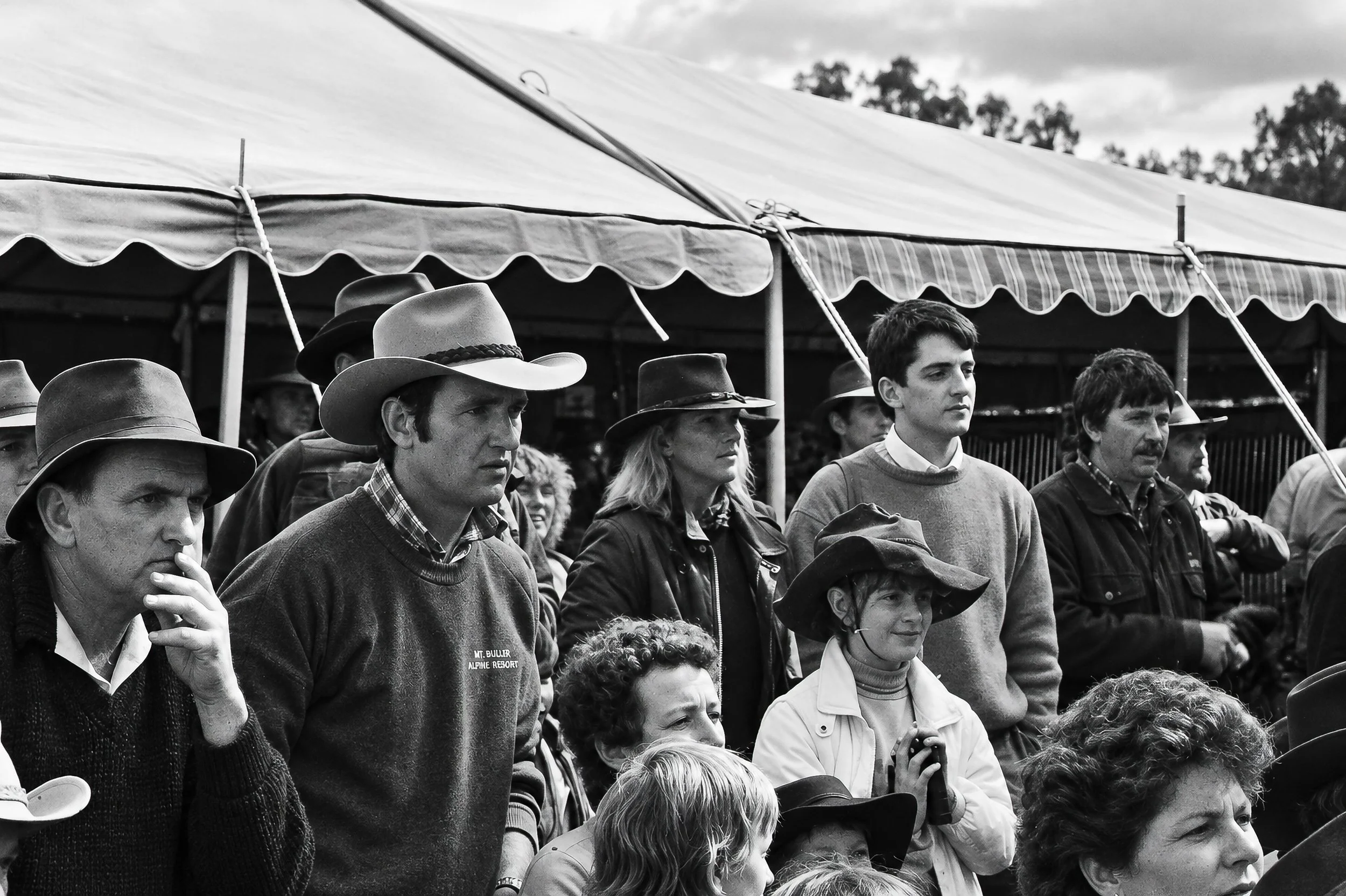 Before the Ride - The crowd gathers beneath the tent at Flinders Park, waiting for the protest procession to begin. Among the faces are cattlemen, supporters and younger members of the community, captured in an unposed moment.